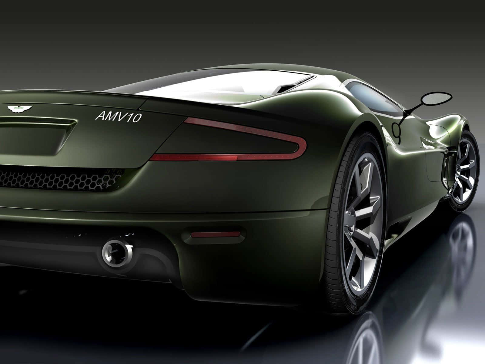 Top 10 Car 桌布 壁紙 — 一輛時尚的橄欖綠色 Aston Martin AMV10 跑車，配備紅色尾燈和鍍鉻輪圈，從後方四分之三角度展示在反光的地板工作室上。