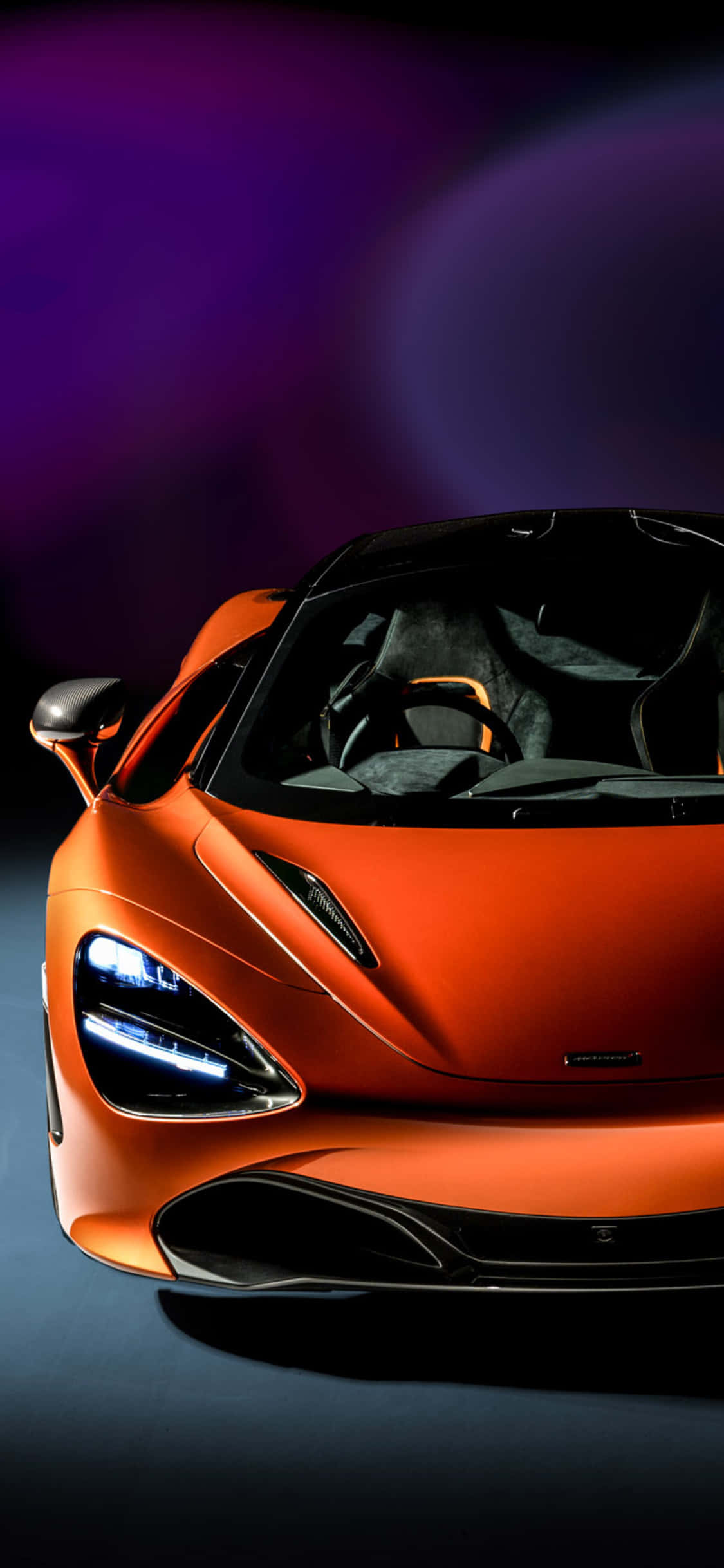 電玩遊戲 桌布 壁紙 — 一輛時尚的橙色McLaren跑車，配以發光的車頭燈，在充滿活力的紫色和藍色漸變背景上展示。