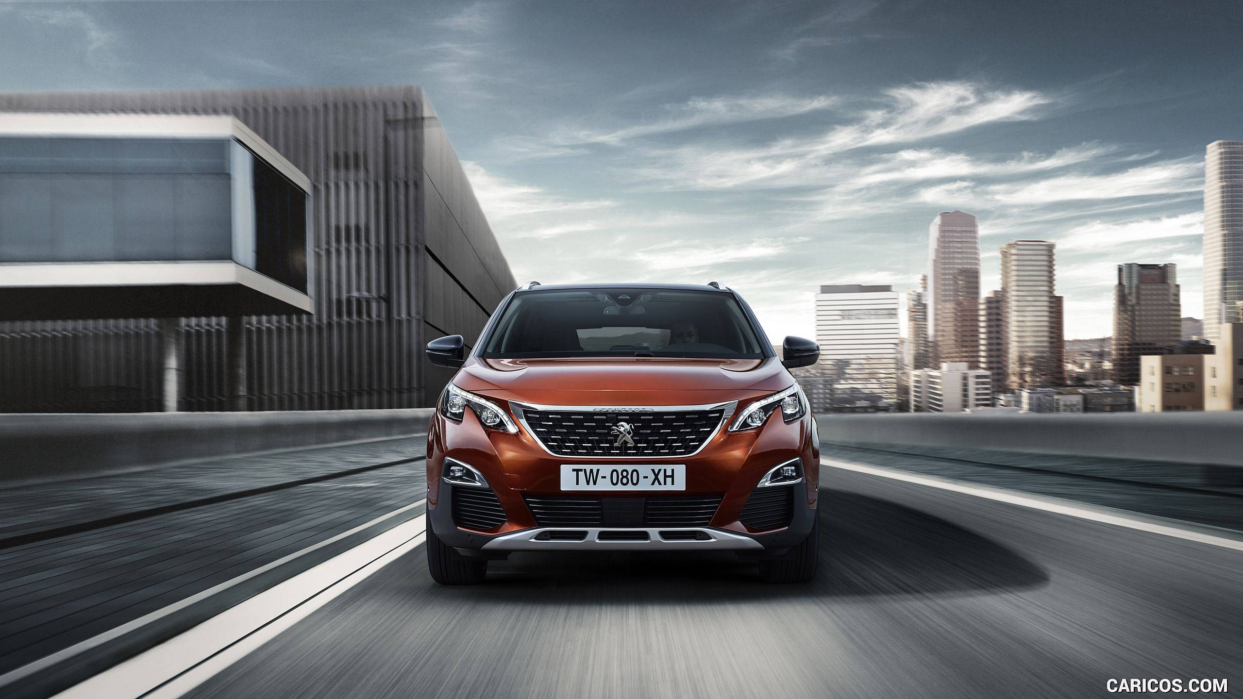 Peugeot 桌布 壁紙 — 一輛時尚的橙色SUV在現代高速公路上疾馳，背景是未來主義的城市天際線和戲劇性的雲層。