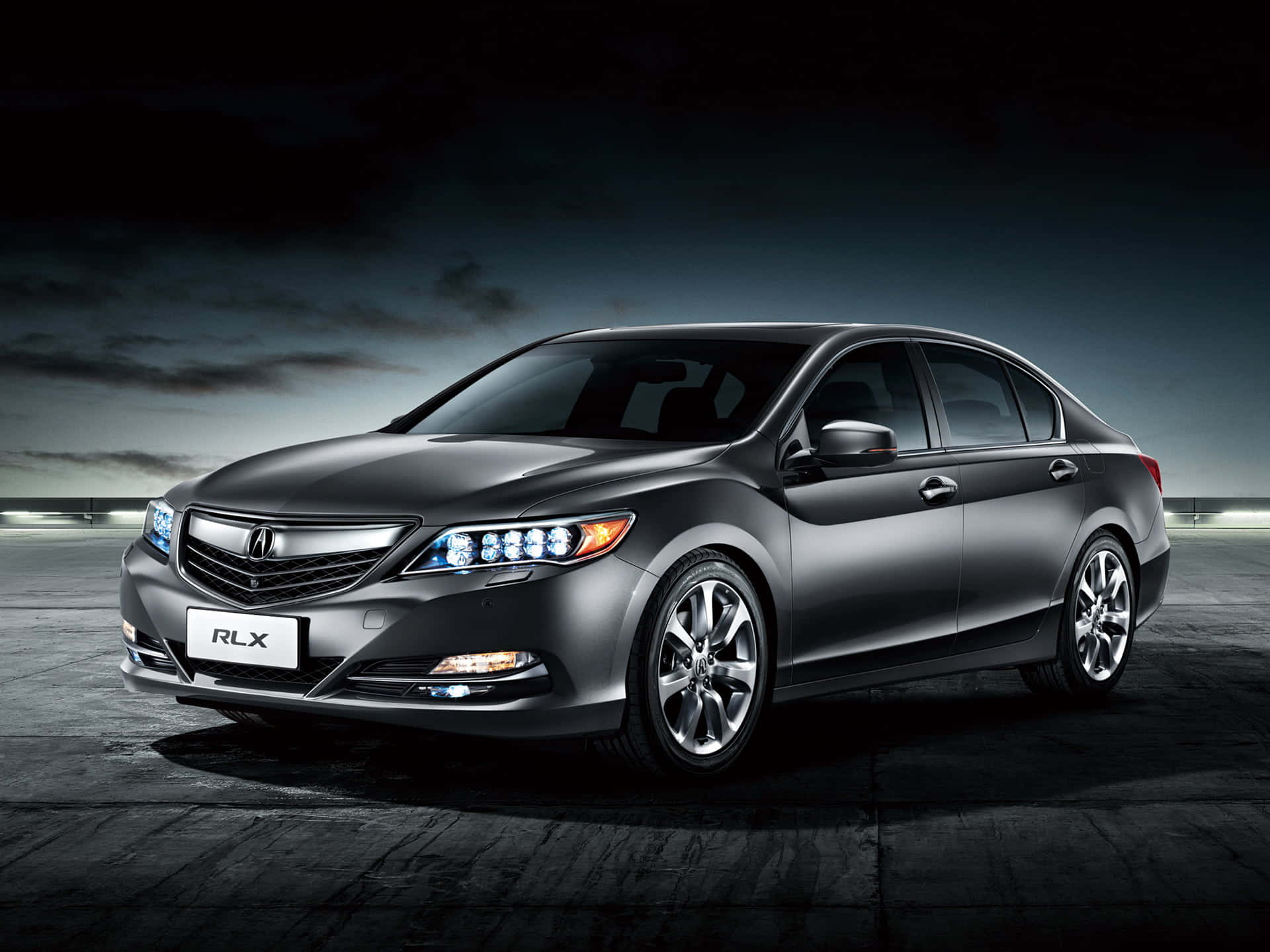 Acura Rlx 桌布 壁紙 — 一輛時尚的消光灰色Acura RLX轎車在戲劇性的攝影棚燈光下，映襯著陰暗多雲的天空閃閃發光。