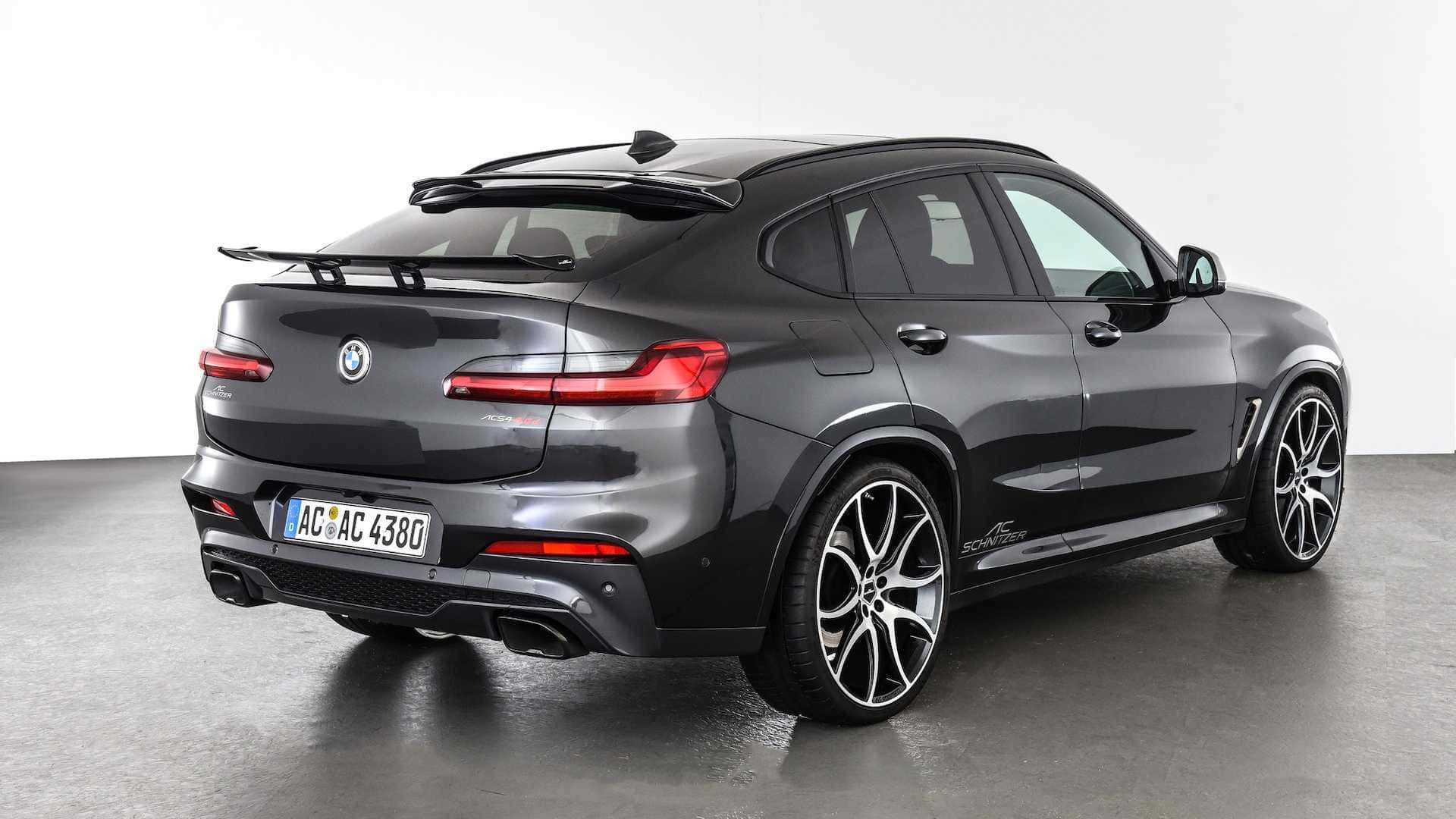Bmw X4 桌布 壁紙 — 一輛時尚的消光灰色BMW X6 M Competition SUV，帶有黑色飾件和定制輪圈，在極簡主義工作室環境中從後方四分之三角度拍攝。