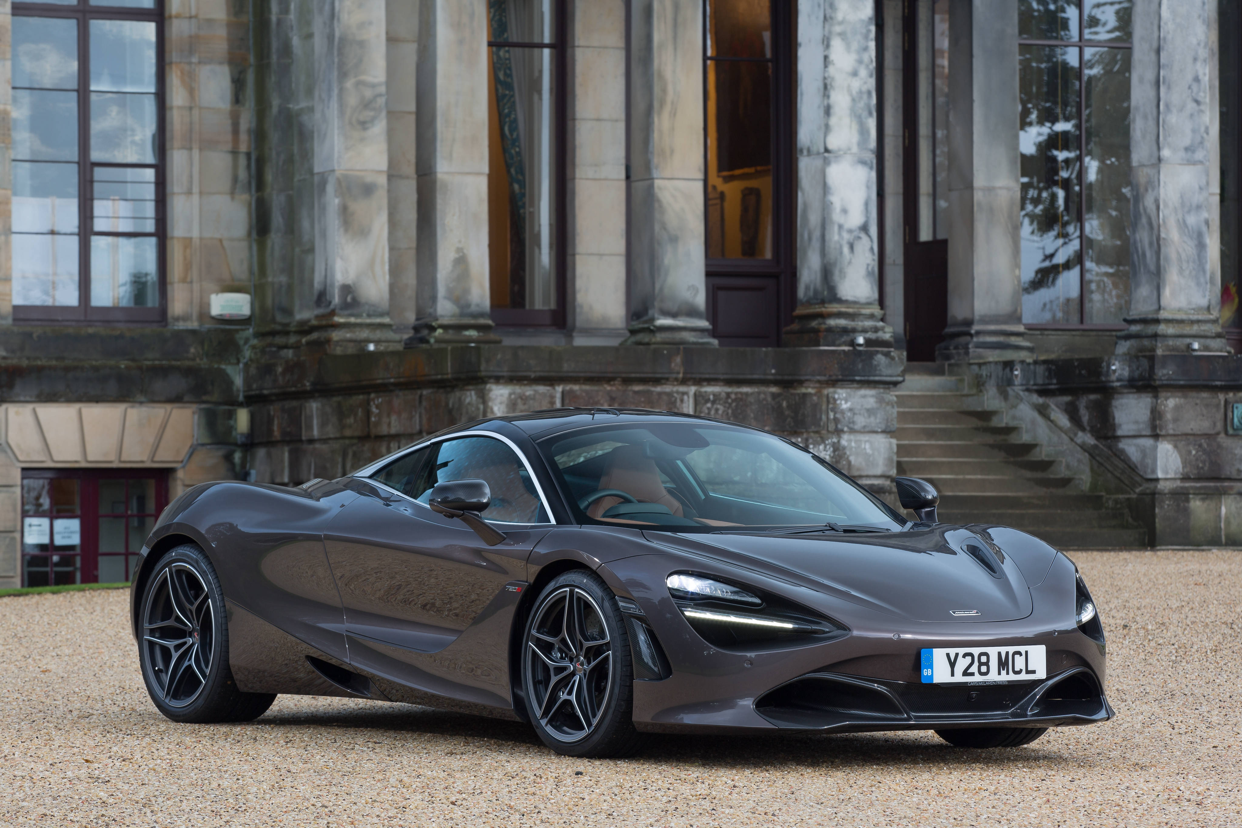 Mclaren 720s 桌布 壁紙 — 一輛時尚的消光灰色McLaren 720S跑車停泊在碎石路上，前方是一座擁有高柱的宏偉石砌大宅。