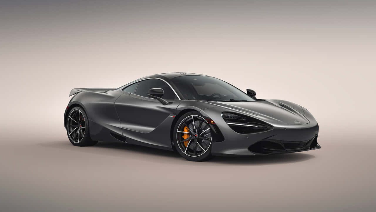 汽車 桌布 壁紙 — 一輛時尚的消光灰色McLaren 720S跑車，配備橙色制動卡鉗，在中性攝影棚背景下展示。