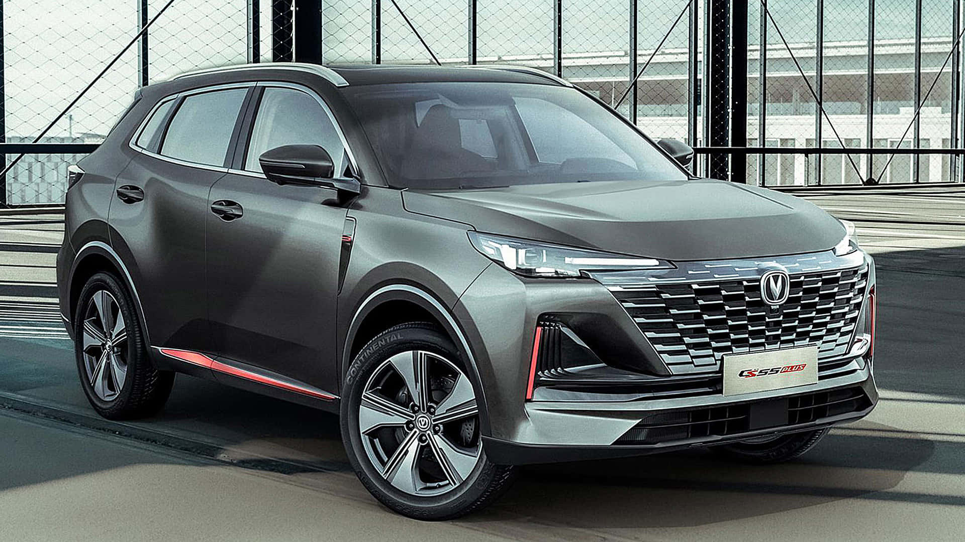 Changan 桌布 壁紙 — 一輛時尚的消光灰色SUV，帶有紅色飾條，停在現代混凝土平台上，沐浴在明亮的日光下。