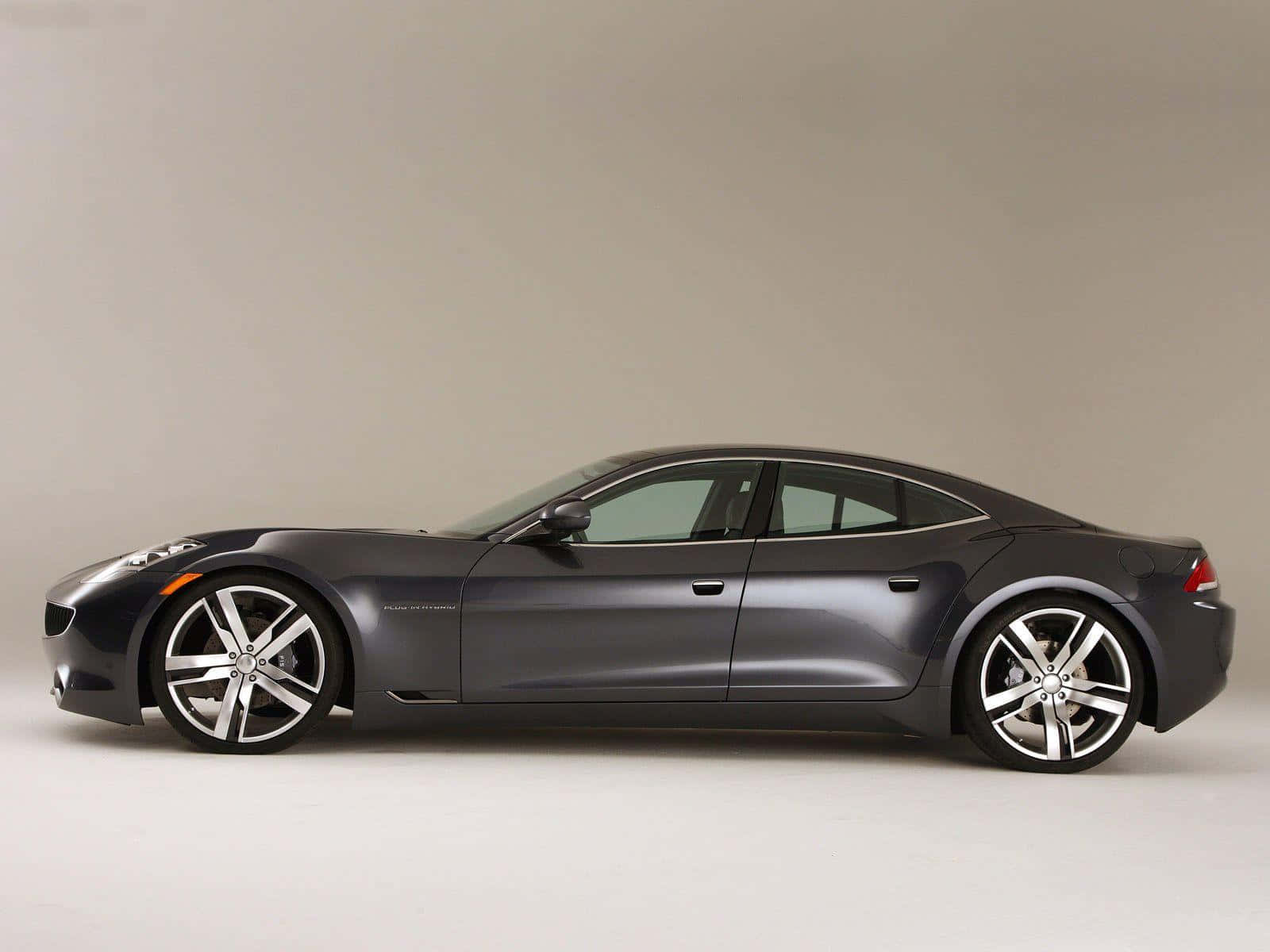 Fisker 桌布 壁紙 — 一輛時尚的消光灰色跑車配備銀色合金輪圈，在中性工作室背景前以側面展示。