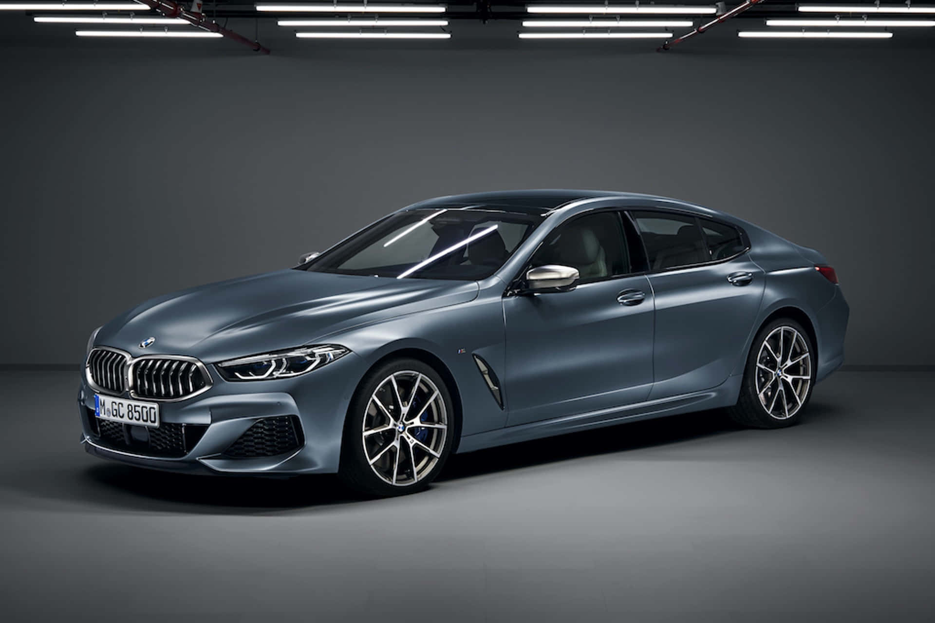 Bmw 8 Series 桌布 壁紙 — 一輛時尚的消光藍色BMW 8系列Gran Coupe在極簡灰色車庫的攝影棚燈光下閃耀。