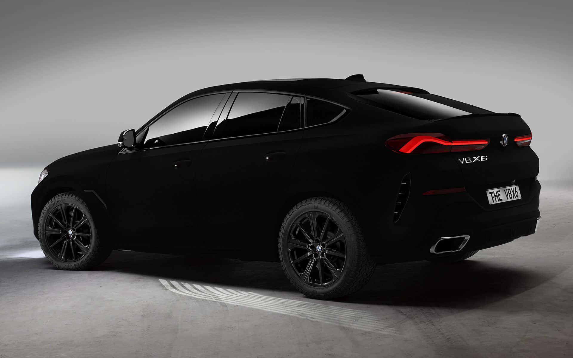 Vantablack 桌布 壁紙 — 一輛時尚的消光黑色BMW X6，搭配發光的紅色尾燈，在簡約的攝影棚環境中靜立。