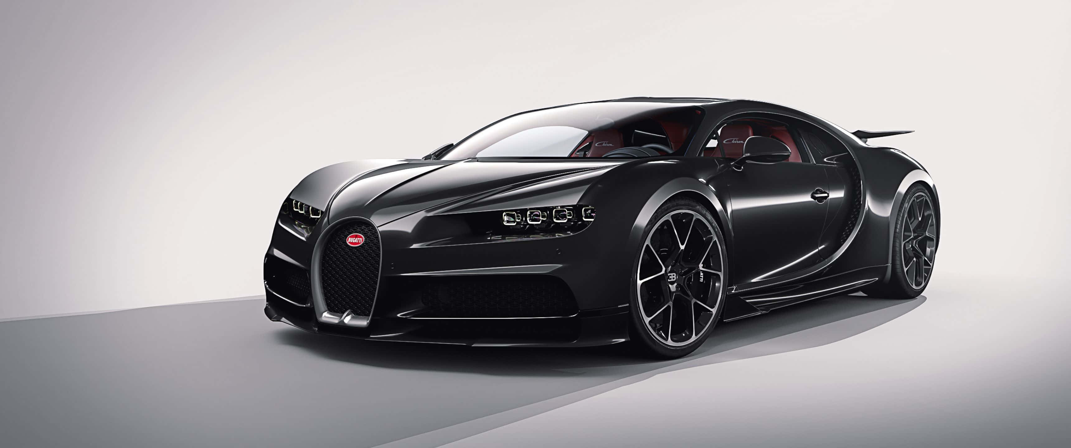 3440x1440p Bugatti 桌布 壁紙 — 一輛時尚的消光黑色Bugatti Chiron跑車，配備紅色內裝和黑色輪圈，在極簡工作室環境中展示。
