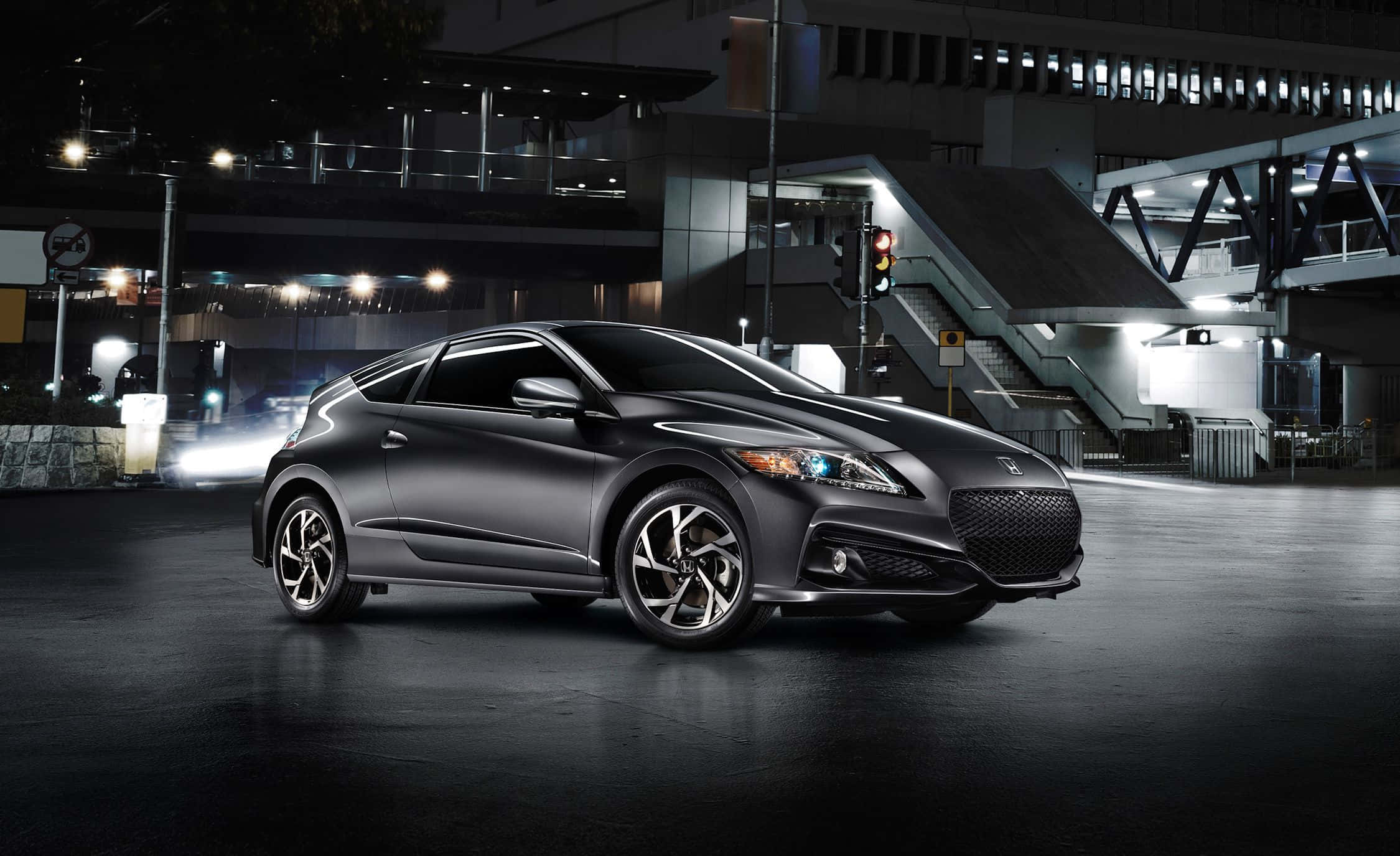 Honda Cr-z 桌布 壁紙 — 一輛時尚的消光黑色跑車在夜間城市環境中，在潮濕路面的倒影下閃爍著城市燈光。
