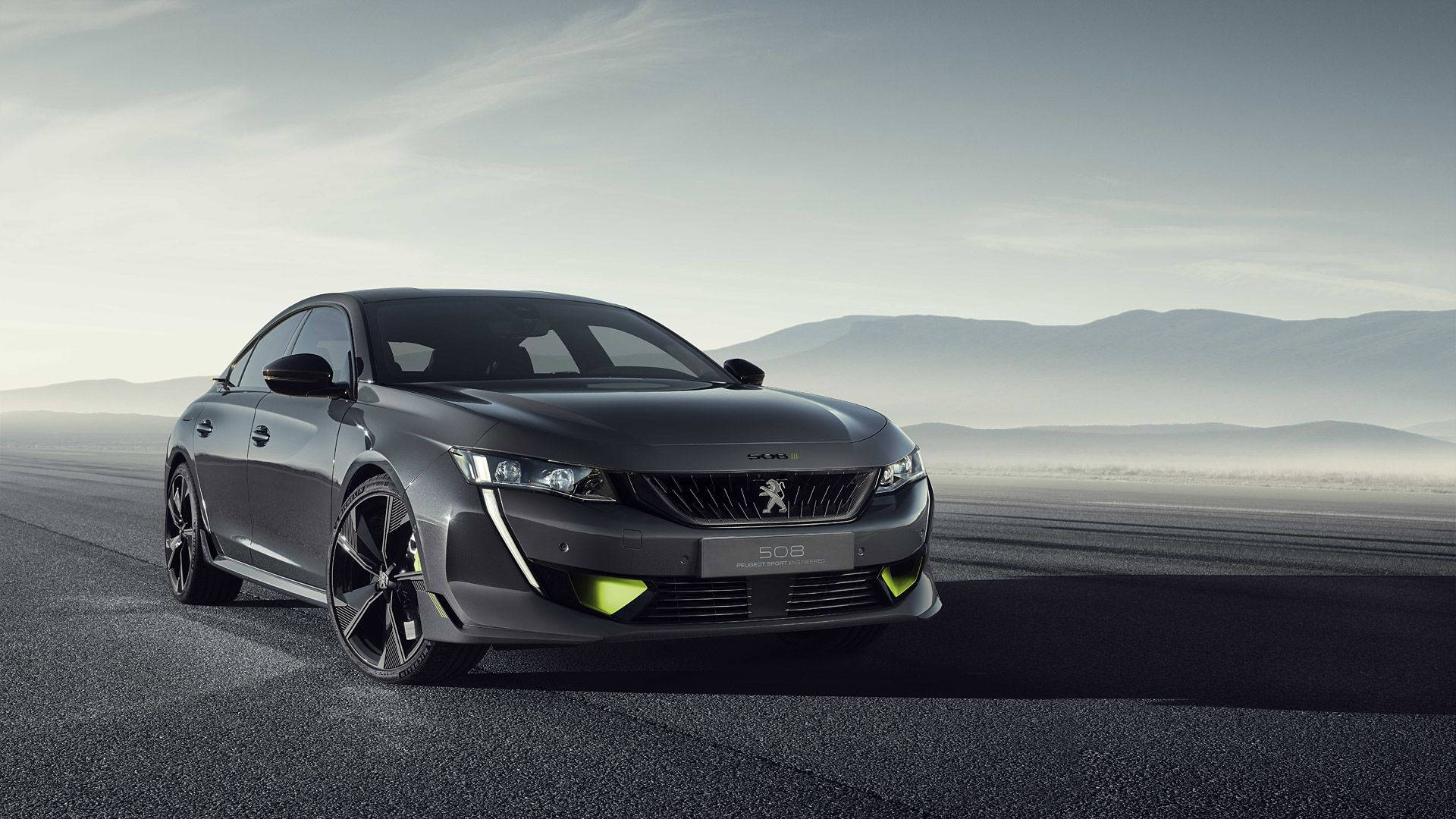 Peugeot 桌布 壁紙 — 一輛時尚的深灰色標緻508運動轎車，帶有霓虹綠色點綴，在朦朧的天空下沿著霧氣瀰漫的山路飛馳。