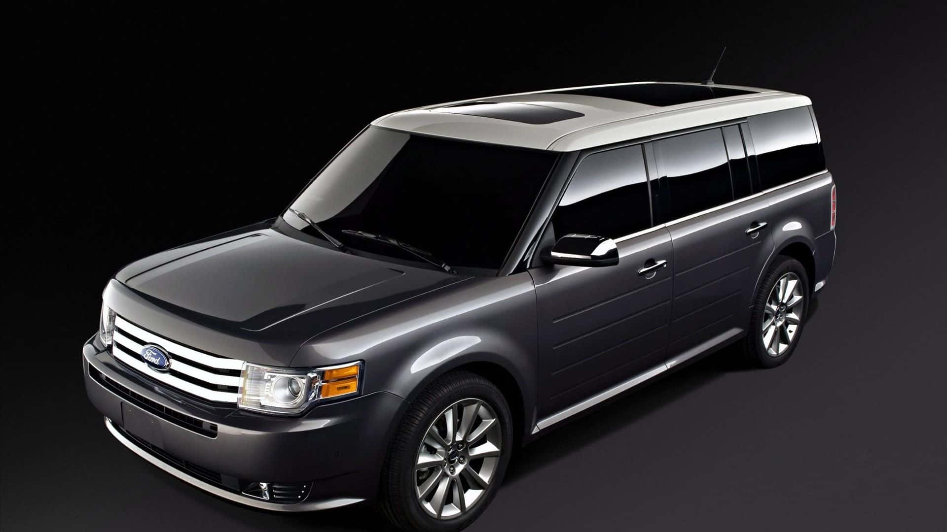 Ford Flex 桌布 壁紙 — 一輛時尚的深灰色福特Flex SUV，帶有鍍鉻飾邊和有色車窗，在黑色工作室背景前展示。