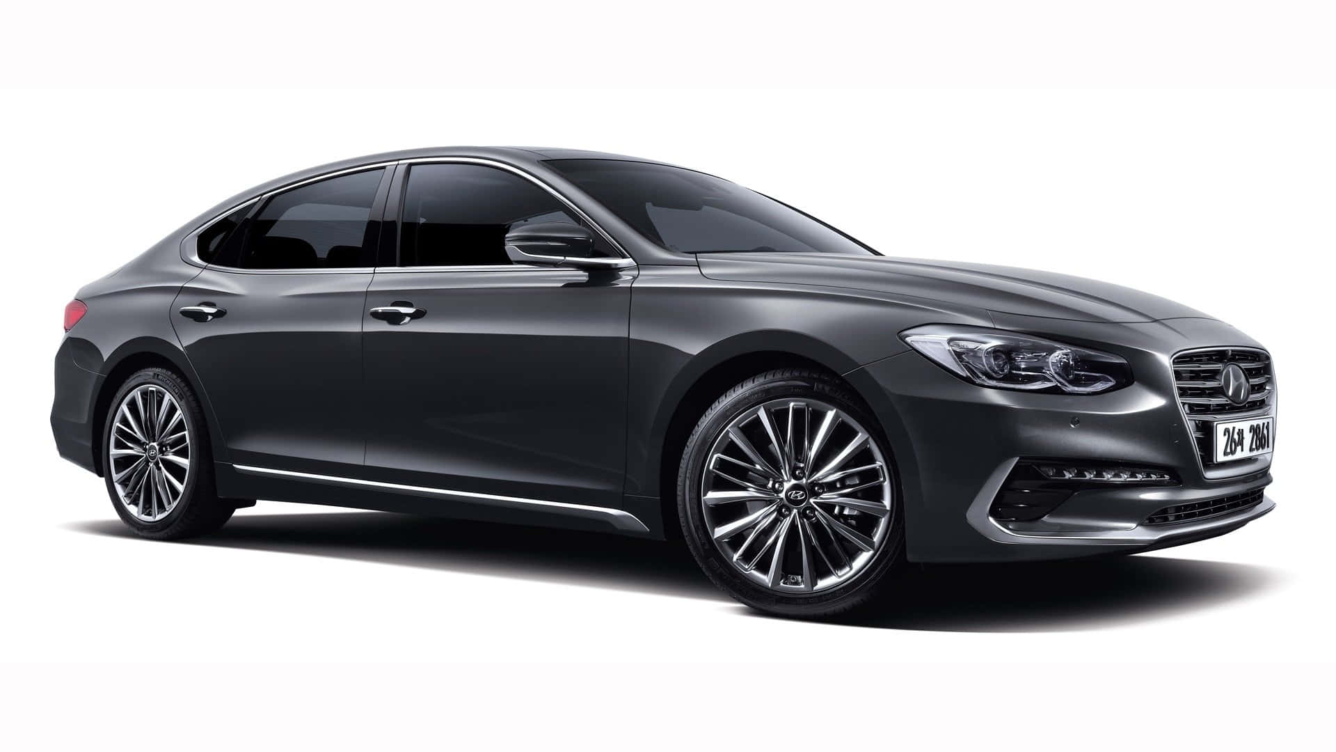 Hyundai Azera 桌布 壁紙 — 一輛時尚的深灰色豪華轎車，帶有鍍鉻裝飾和合金輪圈，在白色背景的攝影棚燈光下展示。