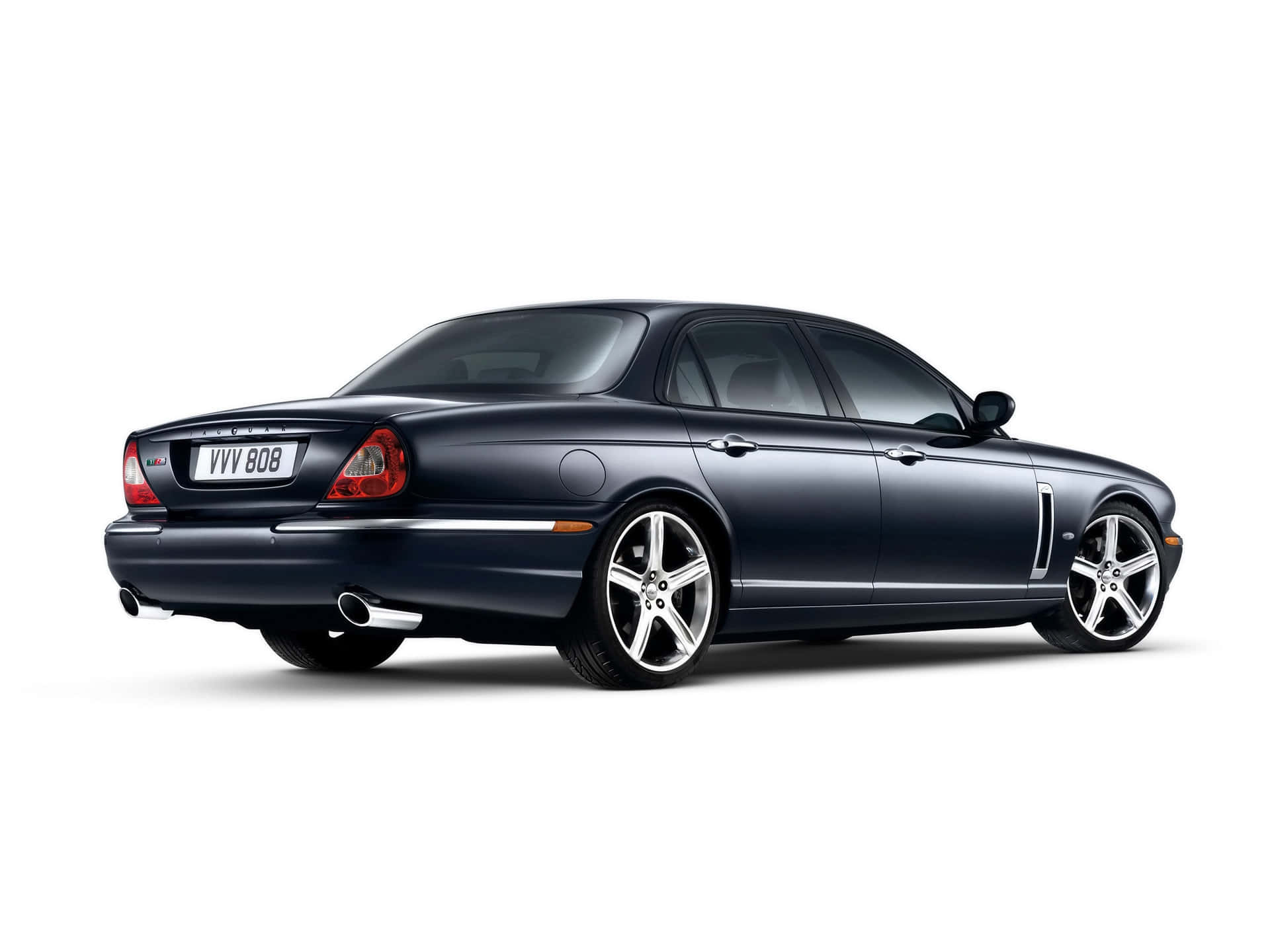 Jaguar Xjr 桌布 壁紙 — 一輛時尚的深藍色積架XJ轎車，在乾淨的白色背景上以側面輪廓展示，配備鍍鉻輪圈和雙排氣管。