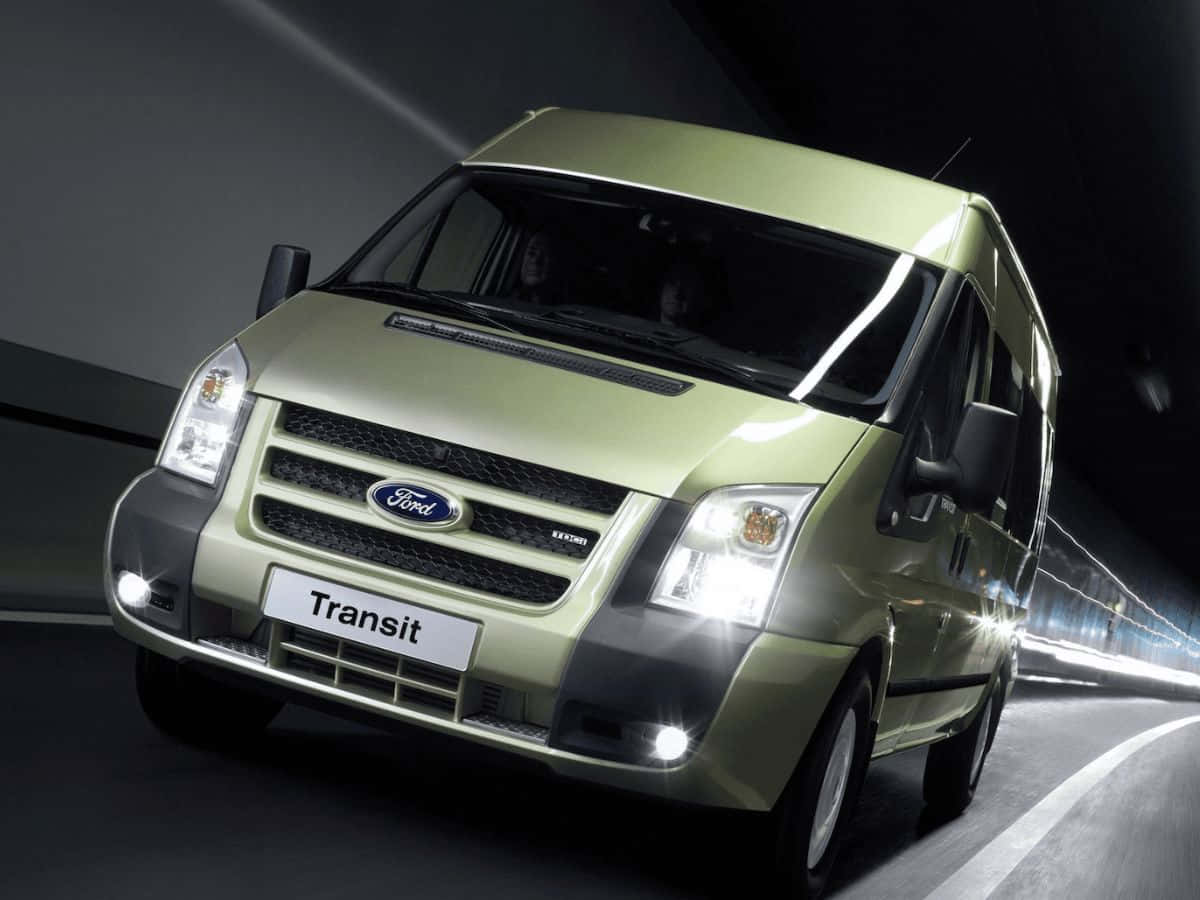 Ford Transit 桌布 壁紙 — 一輛時尚的淺綠色福特全順客貨車在黑暗隧道中疾馳，車頭燈照亮前方濕滑的道路。