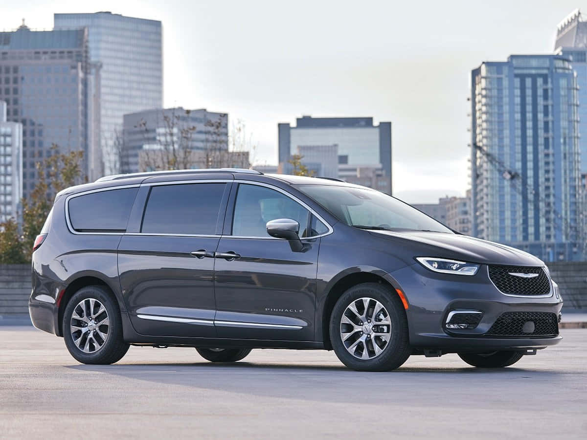 Chrysler 桌布 壁紙 — 一輛時尚的灰色克萊斯勒Pacifica小型貨車停放在城市屋頂上，背景是現代摩天大樓。