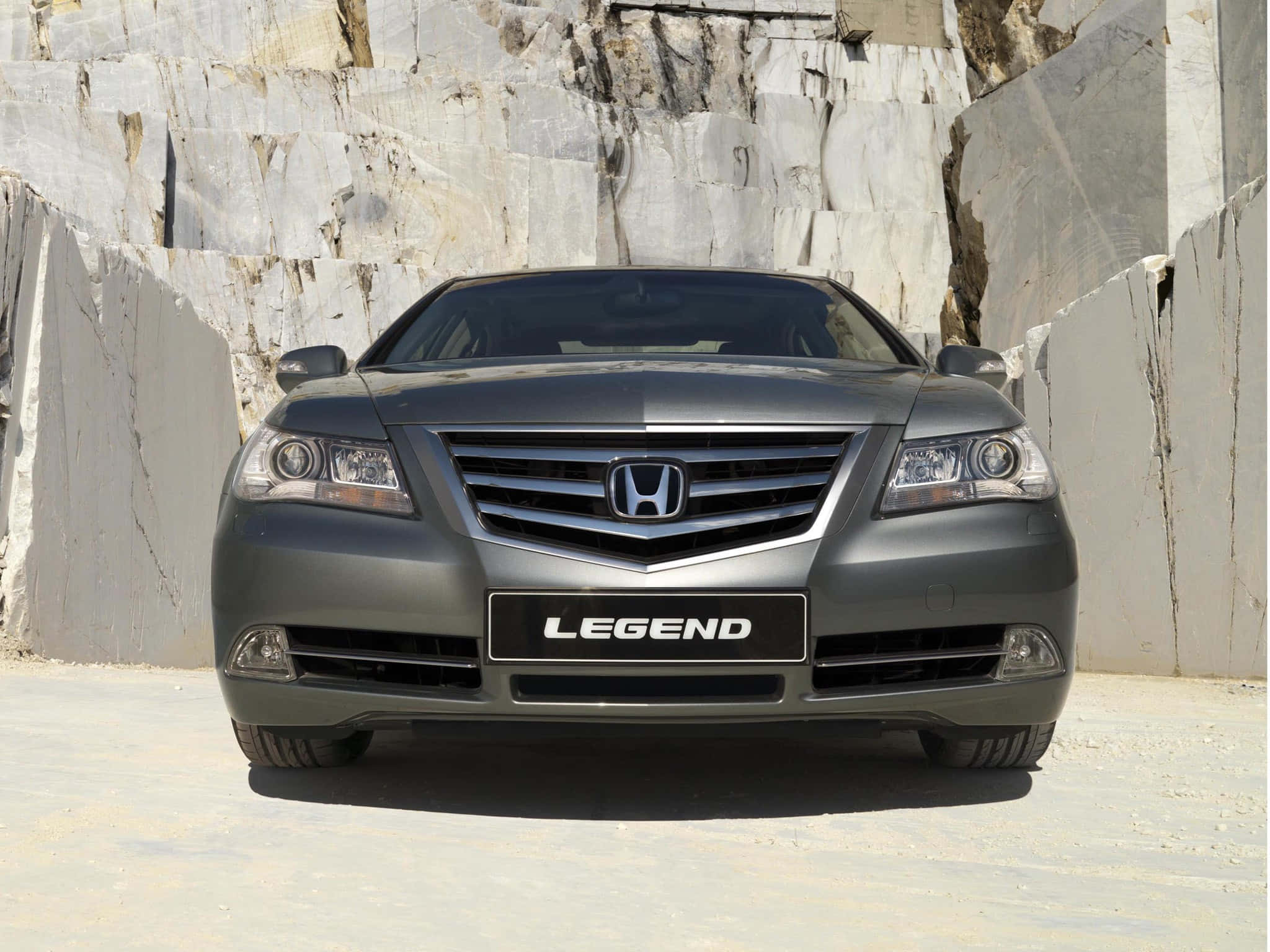 Honda Legend 桌布 壁紙 — 一輛時尚的灰色本田Legend轎車在明亮的日光下，面向一座高聳的白色大理石採石場牆壁。