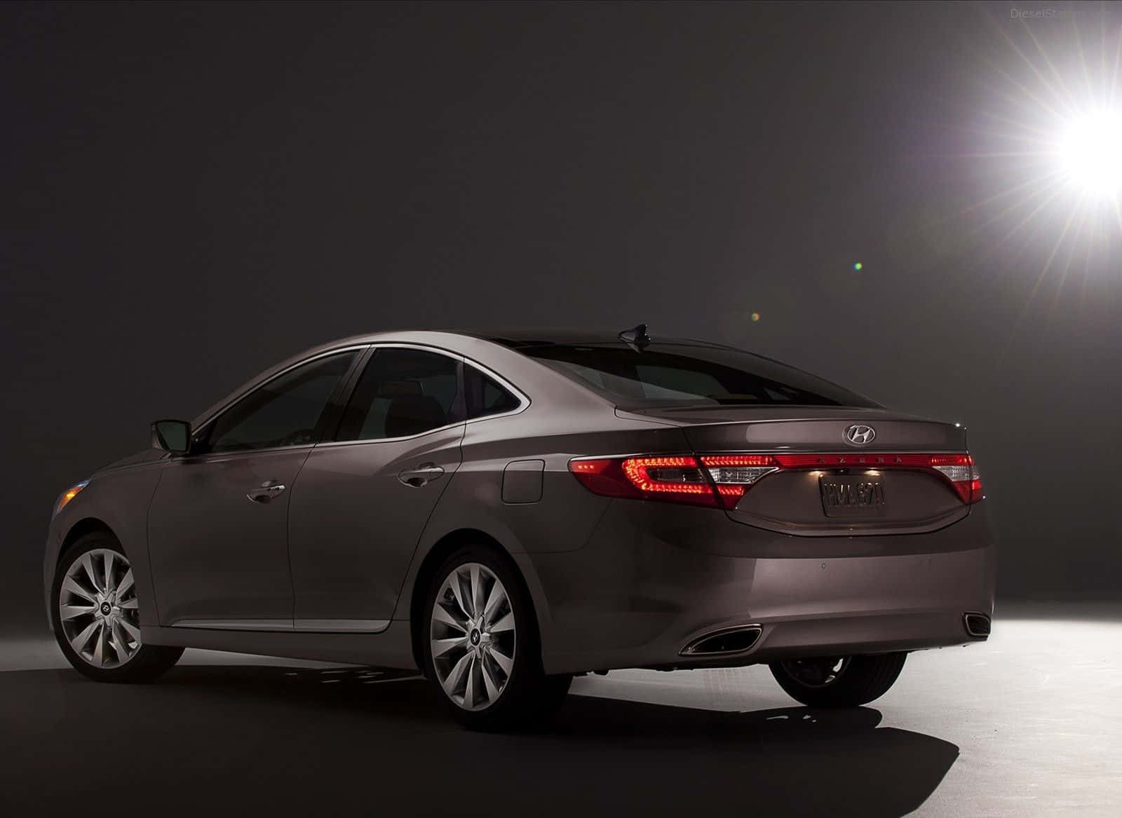 Hyundai Azera 桌布 壁紙 — 一輛時尚的灰色現代轎車在工作室中展示，帶有戲劇性的背光和鏡頭光暈。