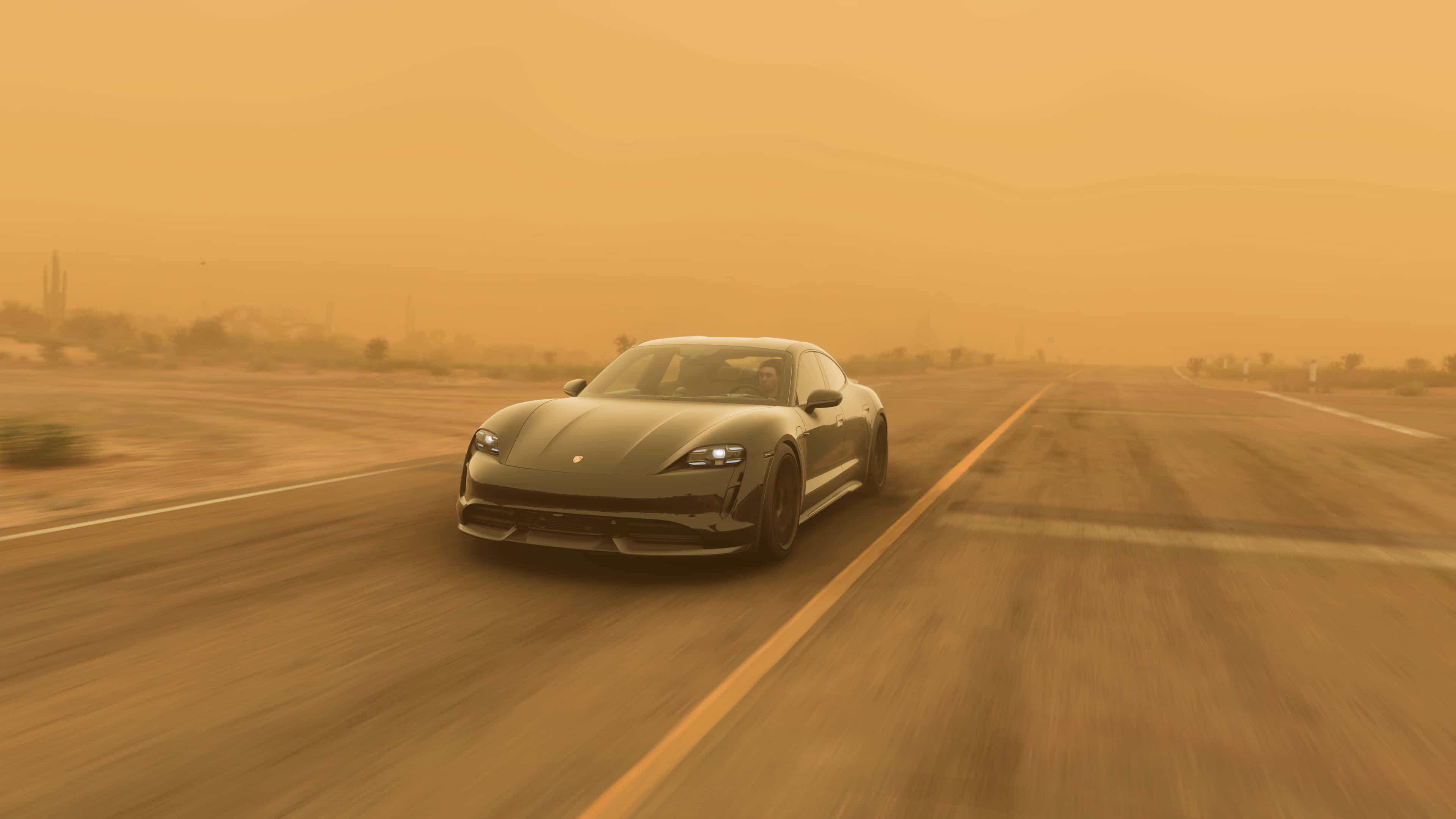 Forza Horizon 5 4K 桌布 壁紙 — 一輛時尚的灰色跑車在朦朧的橙色天空下，沿著沙漠高速公路飛馳，帶有模糊的運動線條。