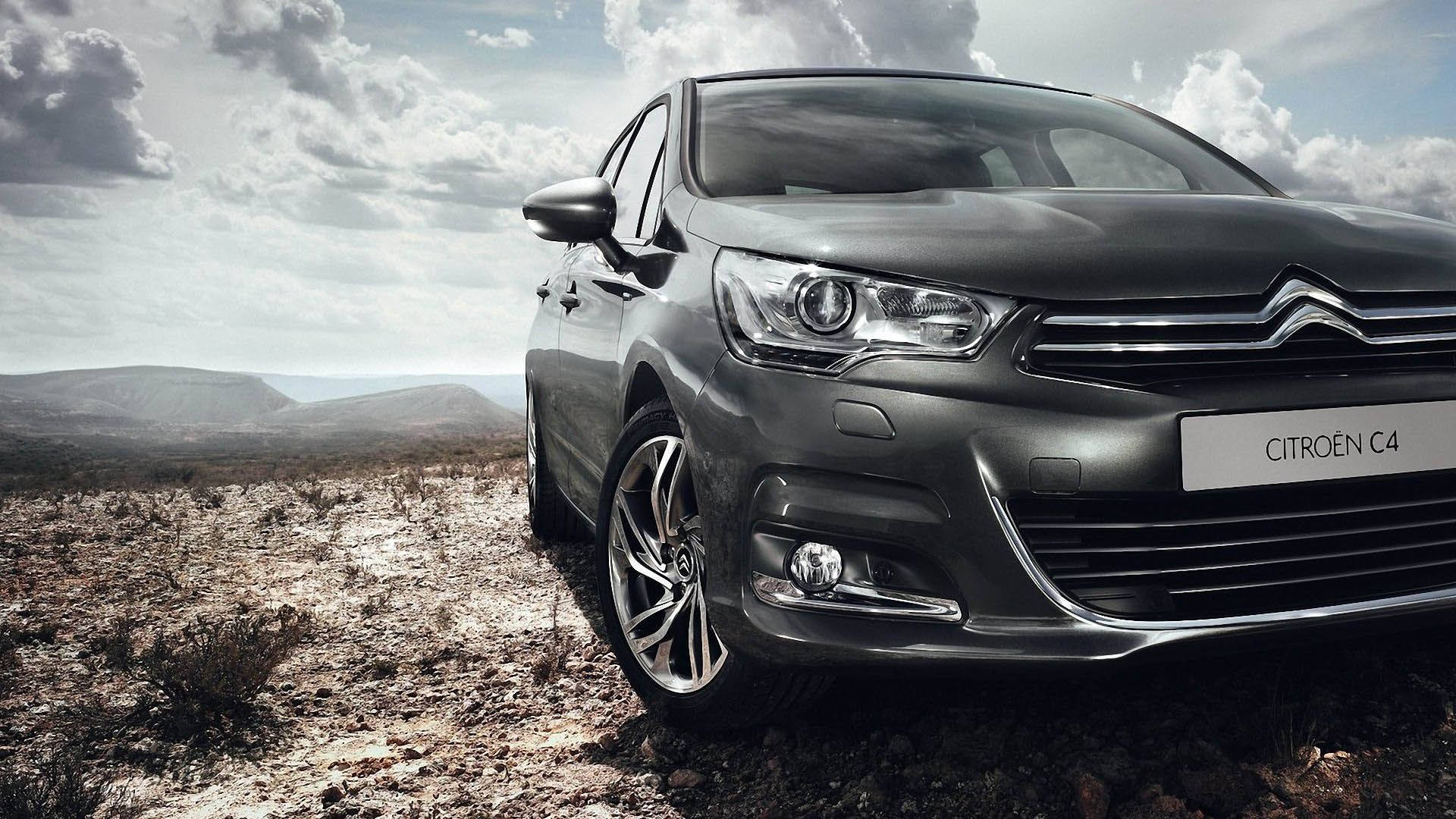 Citroen 桌布 壁紙 — 一輛時尚的灰色雪鐵龍C4轎車停泊在崎嶇地形上，天空多雲，遠處有山丘。