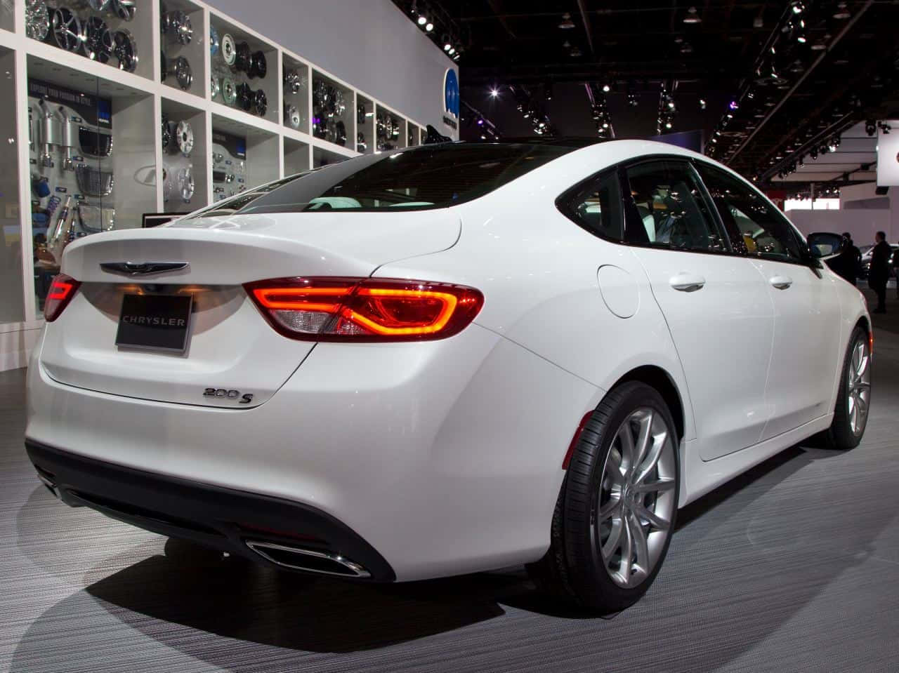 克萊斯勒 桌布 壁紙 — 一輛時尚的白色 Chrysler 200S 轎車在車展上展出，配備發光的尾燈和鍍鉻輪圈，在明亮的展覽燈光下。