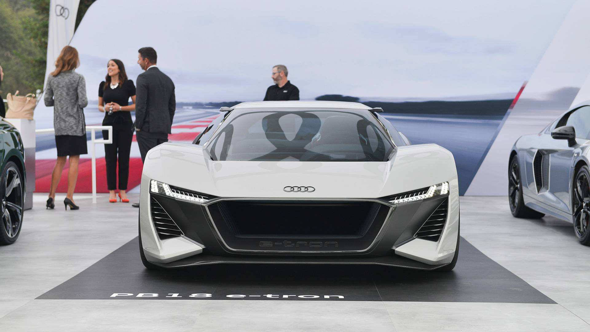 cars 桌布 壁紙 — 一輛時尚的白色Audi PB18 e-tron概念車在汽車活動中展出，與會者正在觀察其未來主義設計。