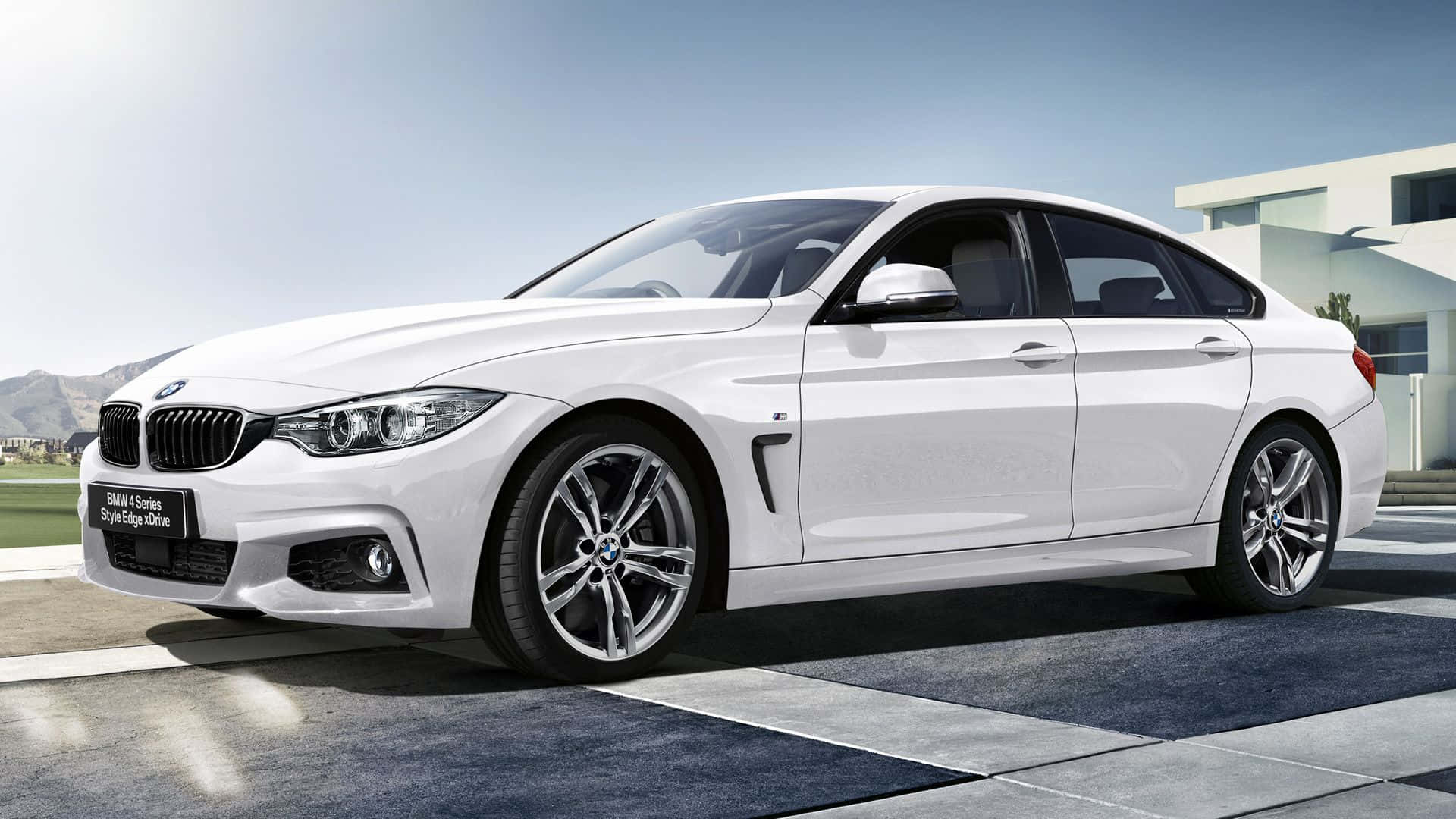 Bmw 4 Series 桌布 壁紙 — 一輛時尚的白色BMW 4系轎跑車停放在現代瓷磚車道上，背景是山脈和晴朗的藍天。