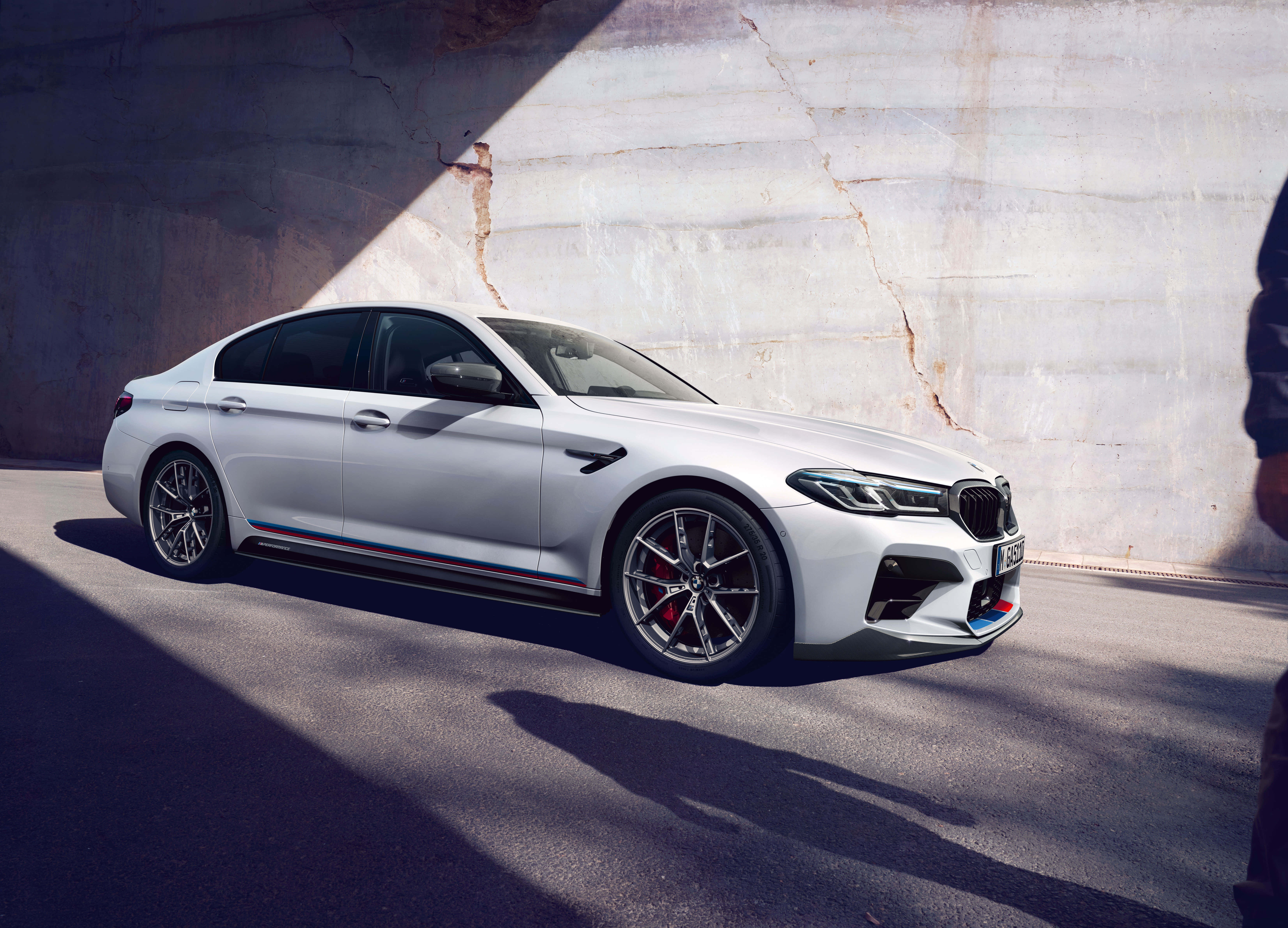 桌布 壁紙 — 一輛時尚的白色BMW M5跑車停泊在混凝土天橋下，戲劇性的陽光投射出銳利的陰影。