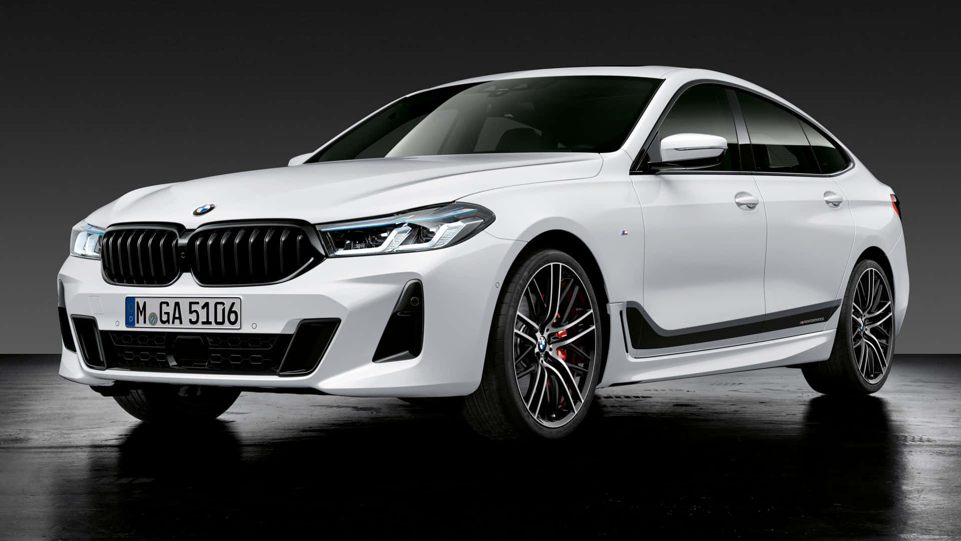 Bmw Laptop 桌布 壁紙 — 一輛時尚的白色BMW M5轎車，帶有黑色飾件和紅色制動卡鉗，在深色工作室背景下展示。