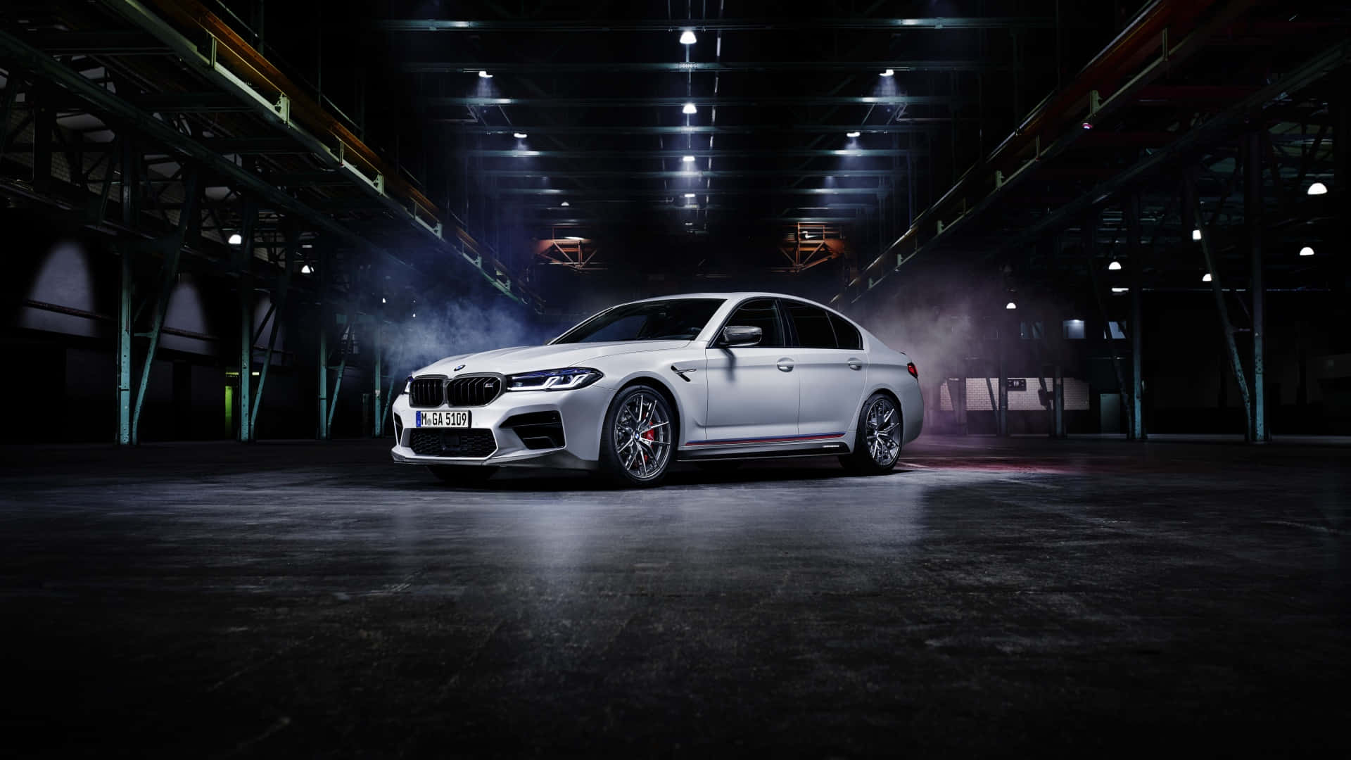 桌布 壁紙 — 一輛時尚的白色BMW M5轎車在煙霧瀰漫的工業倉庫中，於戲劇性的聚光燈下閃耀。