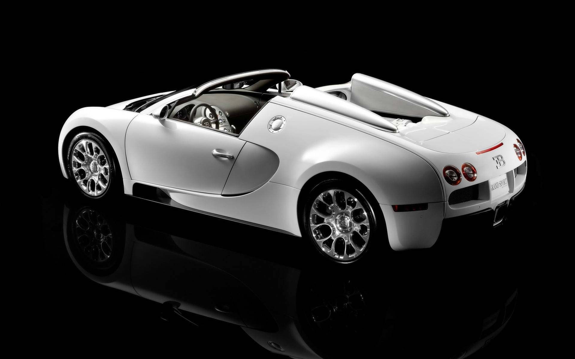 bugatti iPhone 桌布 壁紙 — 一輛時尚的白色Bugatti Veyron Grand Sport敞篷跑車在攝影棚燈光下，於黑色反光表面上閃閃發光。