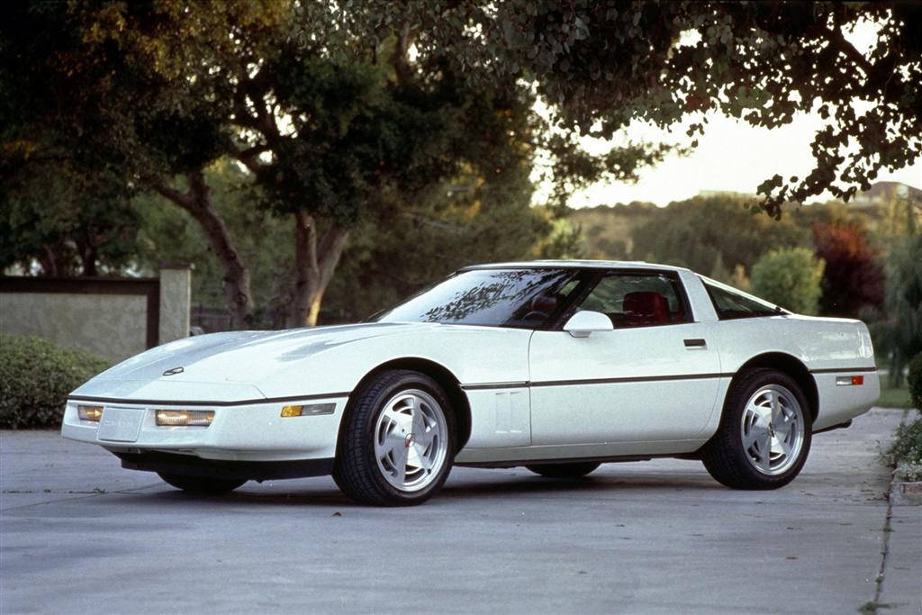 corvette 桌布 壁紙 — 一輛時尚的白色Corvette跑車在黃金時段停泊在鋪砌車道上，上方是枝葉茂密的樹木。