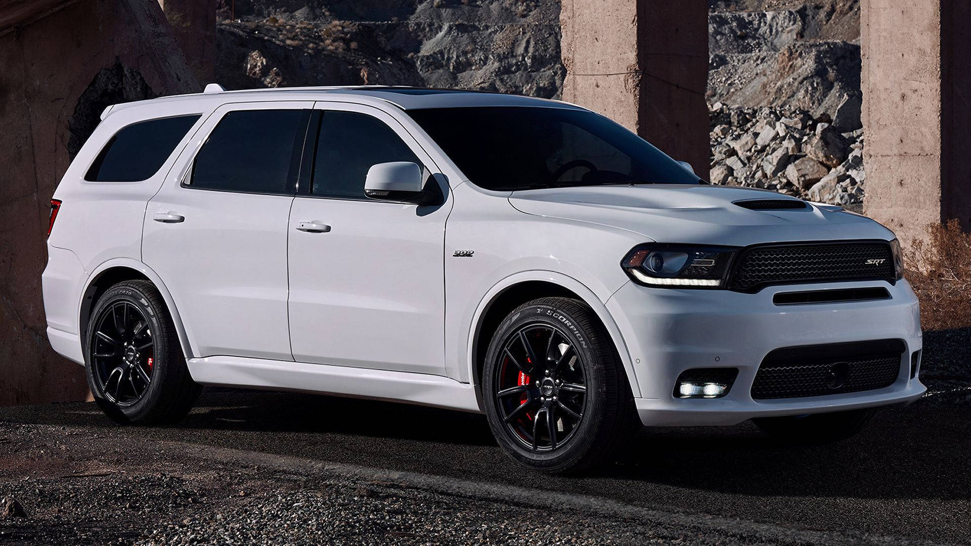 Dodge 桌布 壁紙 — 一輛時尚的白色Dodge Durango SRT停放在混凝土柱下，背景有崎嶇岩石。