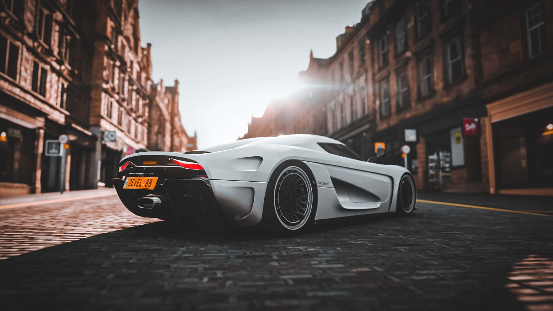 HD Forza Horizon 4 桌布 壁紙 — 一輛時尚的白色Koenigsegg Jesko超跑停在黃金時刻的歷史磚建築之間的鵝卵石街道上。