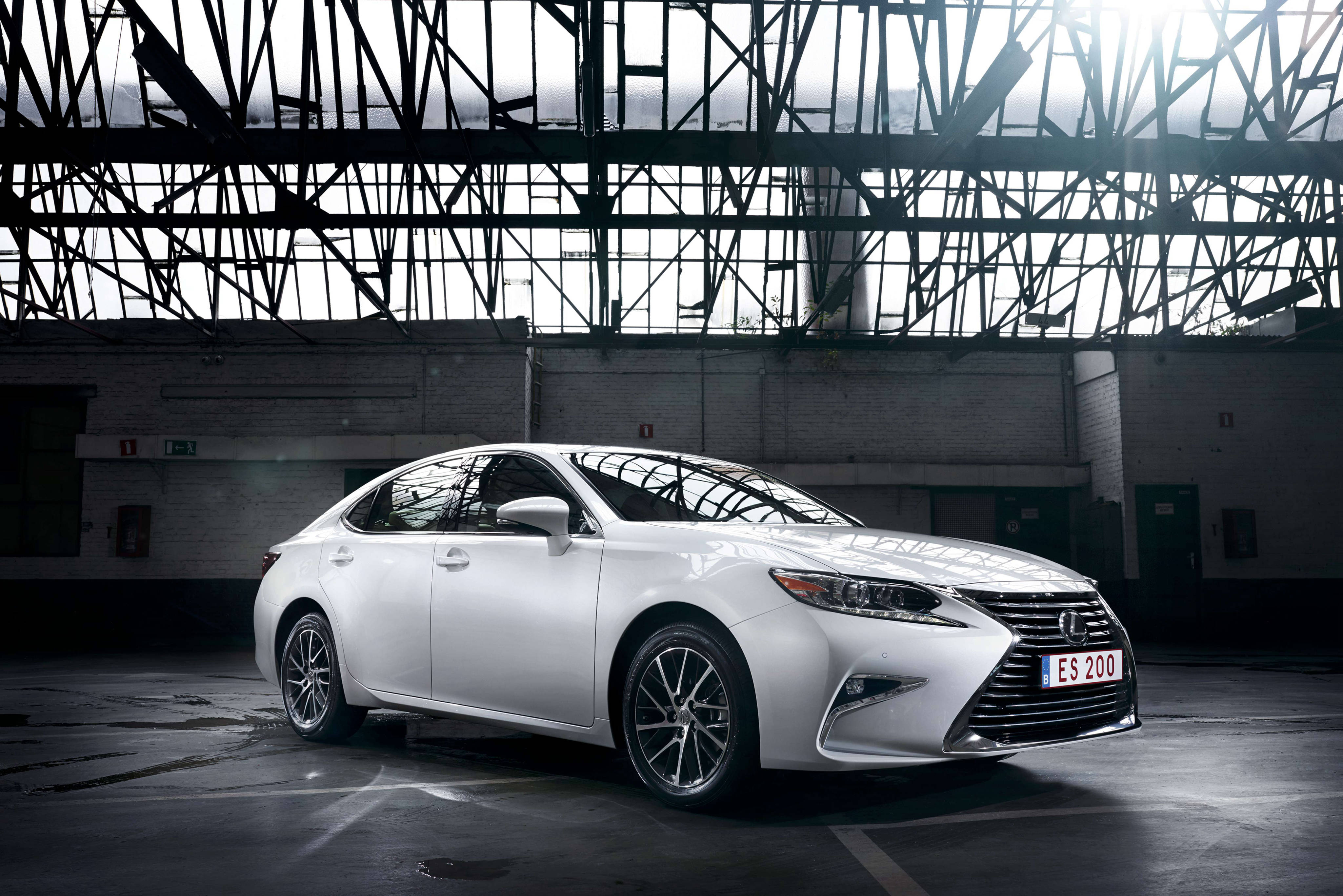 凌志 桌布 壁紙 — 一輛時尚的白色Lexus ES 200轎車在寬敞倉庫內，在暴露的鋼樑下，於戲劇性的工業照明中閃閃發光。