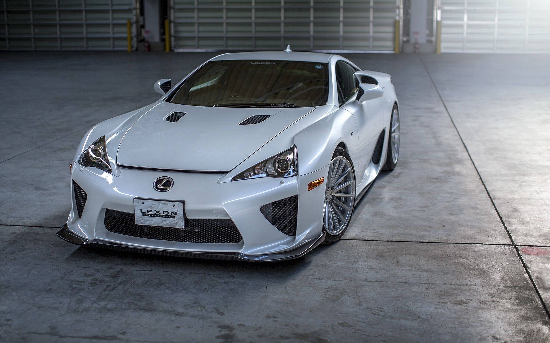 凌志 桌布 壁紙 — 一輛時尚的白色Lexus LFA跑車停放在帶有工業捲簾門的混凝土車庫內。