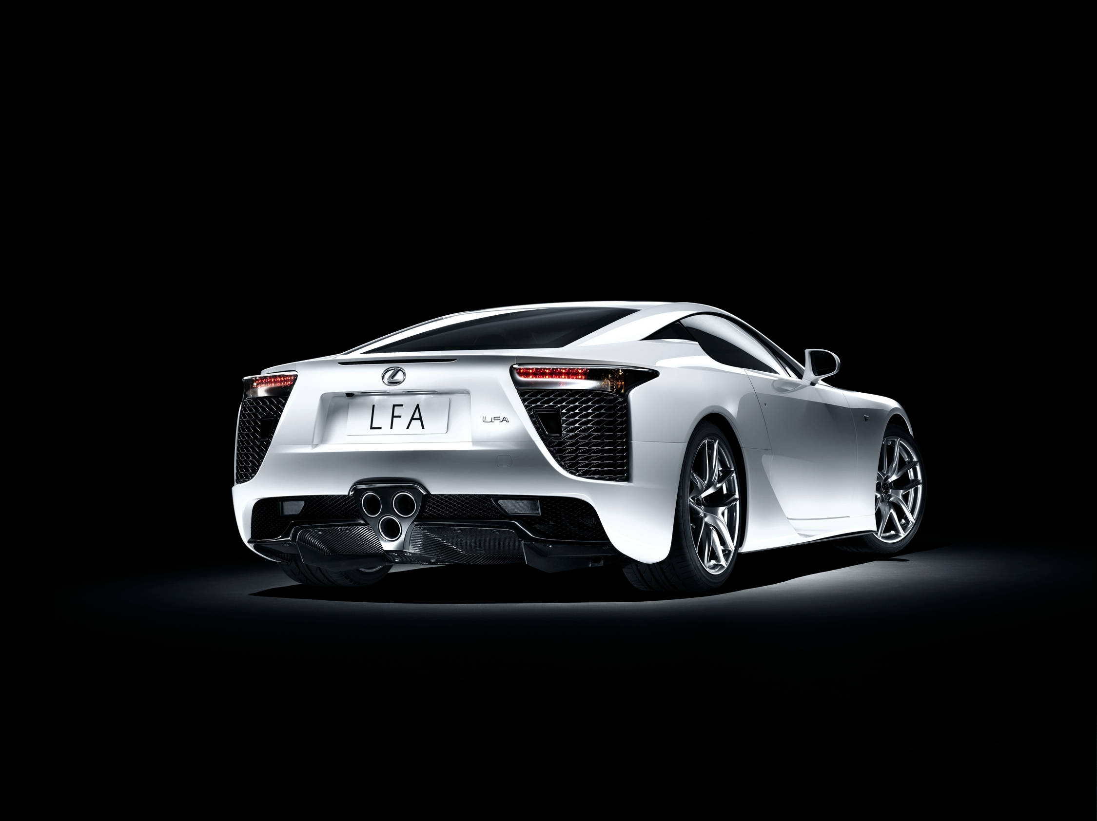 Lexus 桌布 壁紙 — 一輛時尚的白色Lexus LFA跑車以後方四分之三角度展示，背景為純黑色，配以戲劇性的攝影棚燈光。