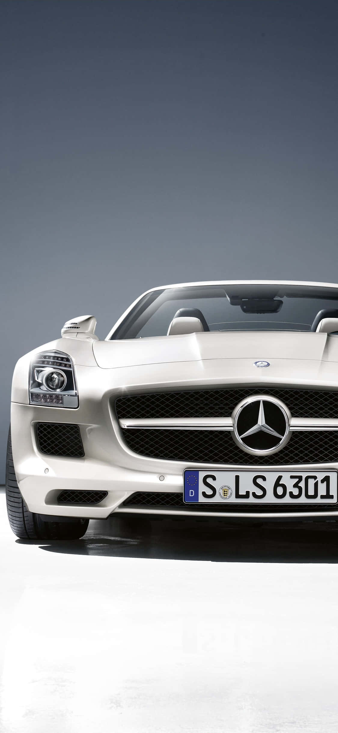 白色 桌布 壁紙 — 一輛時尚的白色Mercedes SLS AMG跑車在漸變灰色背景的攝影棚中展示。