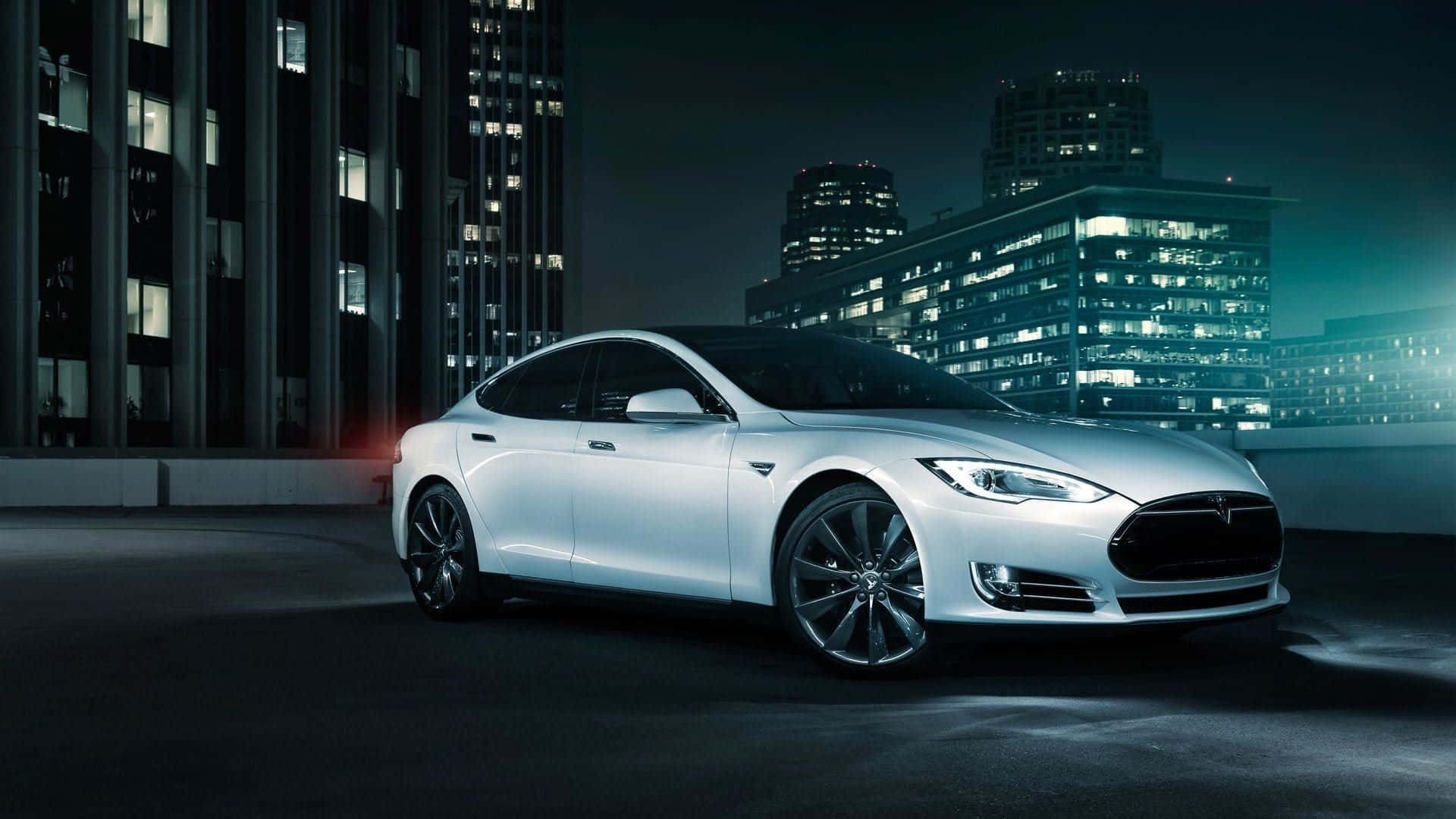 Hybrid Car 桌布 壁紙 — 一輛時尚的白色Tesla轎車在夜晚高聳摩天大樓的背景下，於霓虹城市燈光中閃耀。