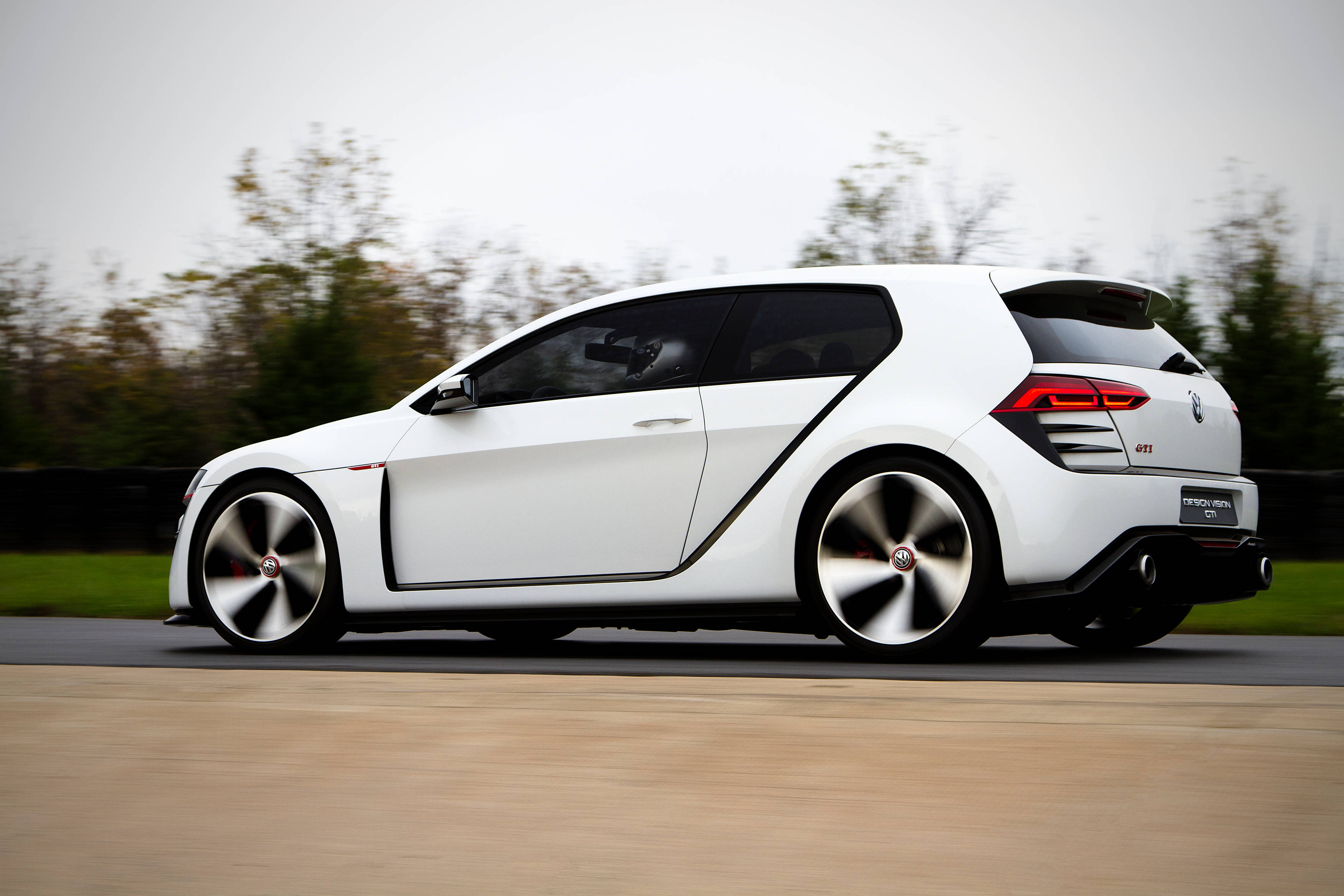 福斯汽車 桌布 壁紙 — 一輛時尚的白色Volkswagen Golf GTI Concept在道路上奔馳，背景是模糊的秋樹。