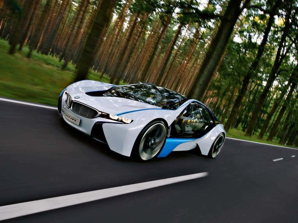 BMW 動圖 桌布 壁紙 — 一輛時尚的白色和藍色BMW i8概念車在森林道路上疾馳，樹木周圍呈現動態模糊效果。