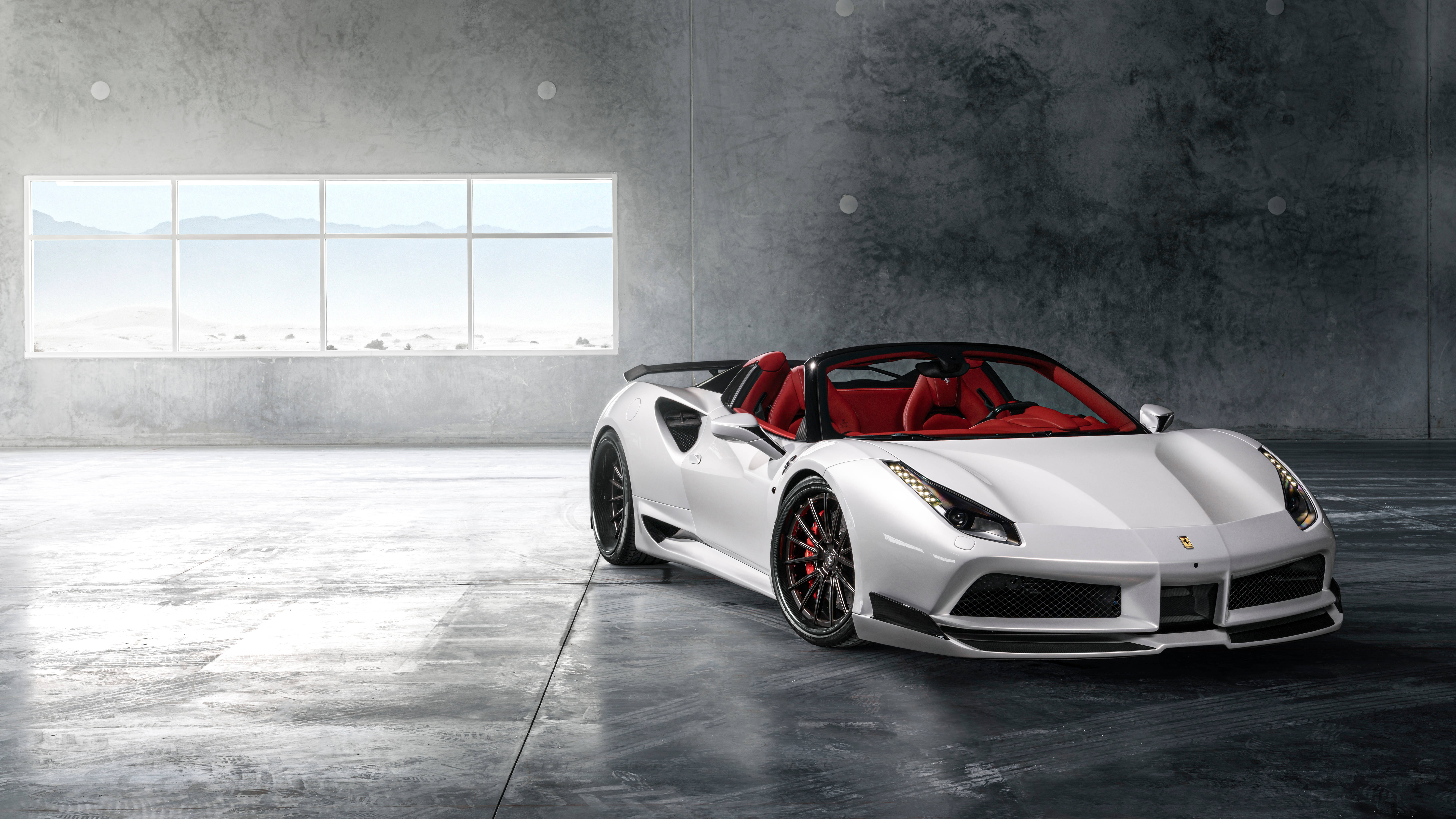 white ferrari 桌布 壁紙 — 一輛時尚的白色法拉利敞篷車，紅色內飾，停放在簡約的混凝土車庫中，透過大窗戶可以看到沙漠景色。
