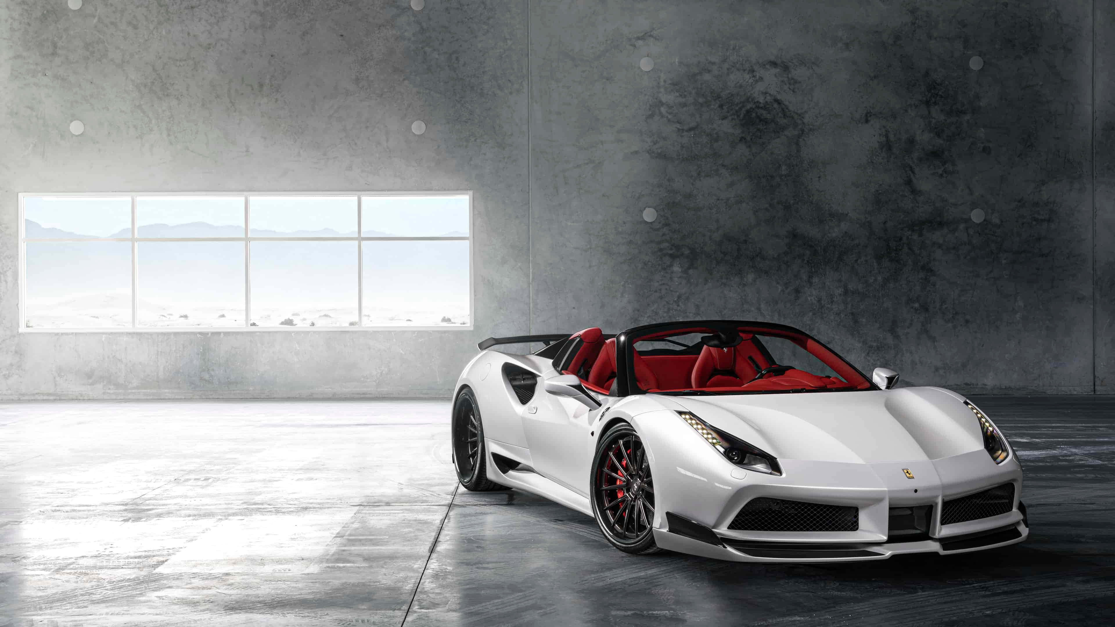 Ferrari 488 Spider 桌布 壁紙 — 一輛時尚的白色法拉利敞篷車，紅色內裝，停放在簡約的混凝土車庫中，透過大窗戶可欣賞山景。