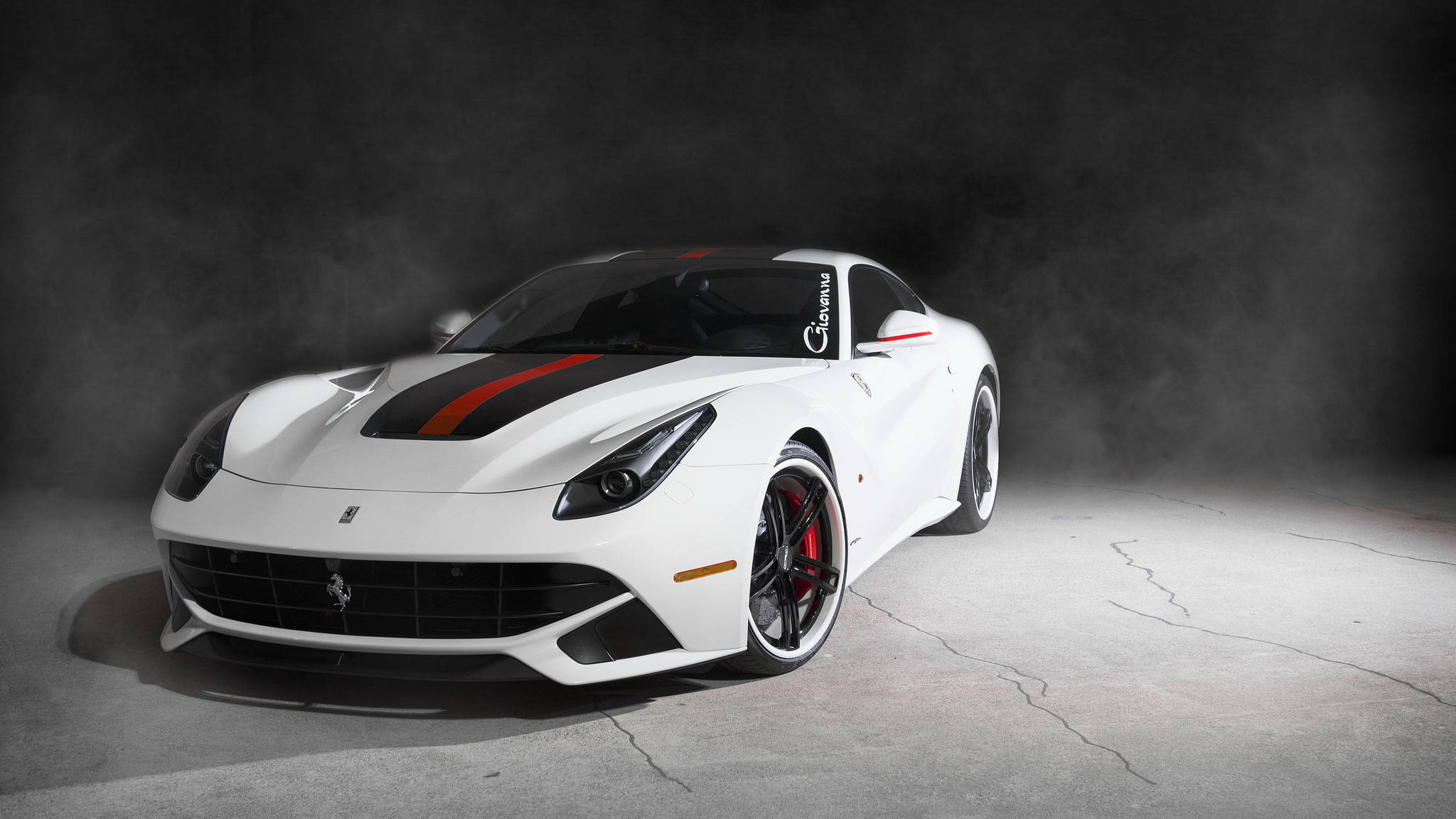 white ferrari 桌布 壁紙 — 一輛時尚的白色法拉利跑車帶有紅色和黑色條紋，在煙霧繚繞的黑暗背景下於攝影棚燈光下閃耀。