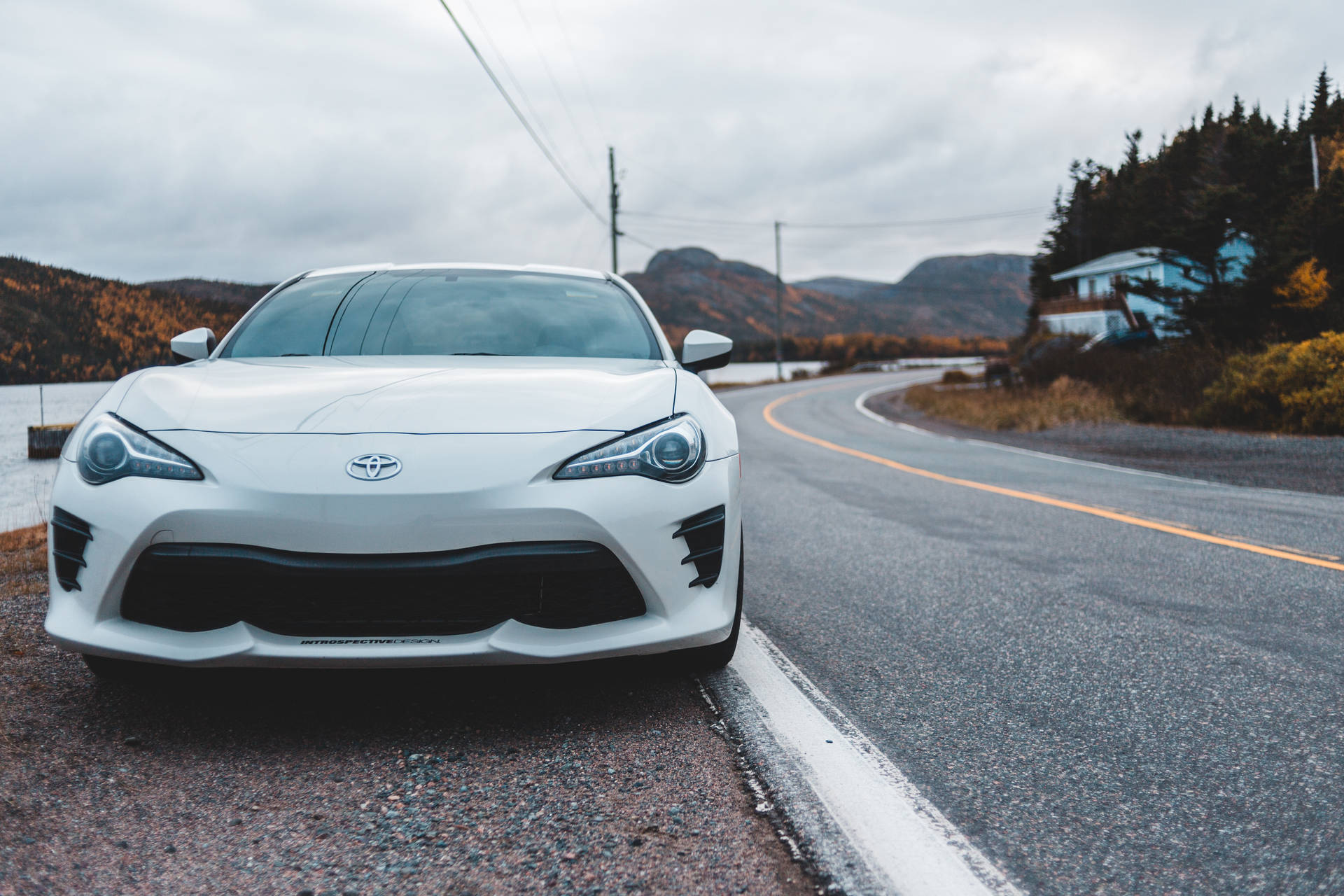 白色跑車停在路邊，背景有秋樹和山脈。 — Toyota Supra Mk4 壁紙