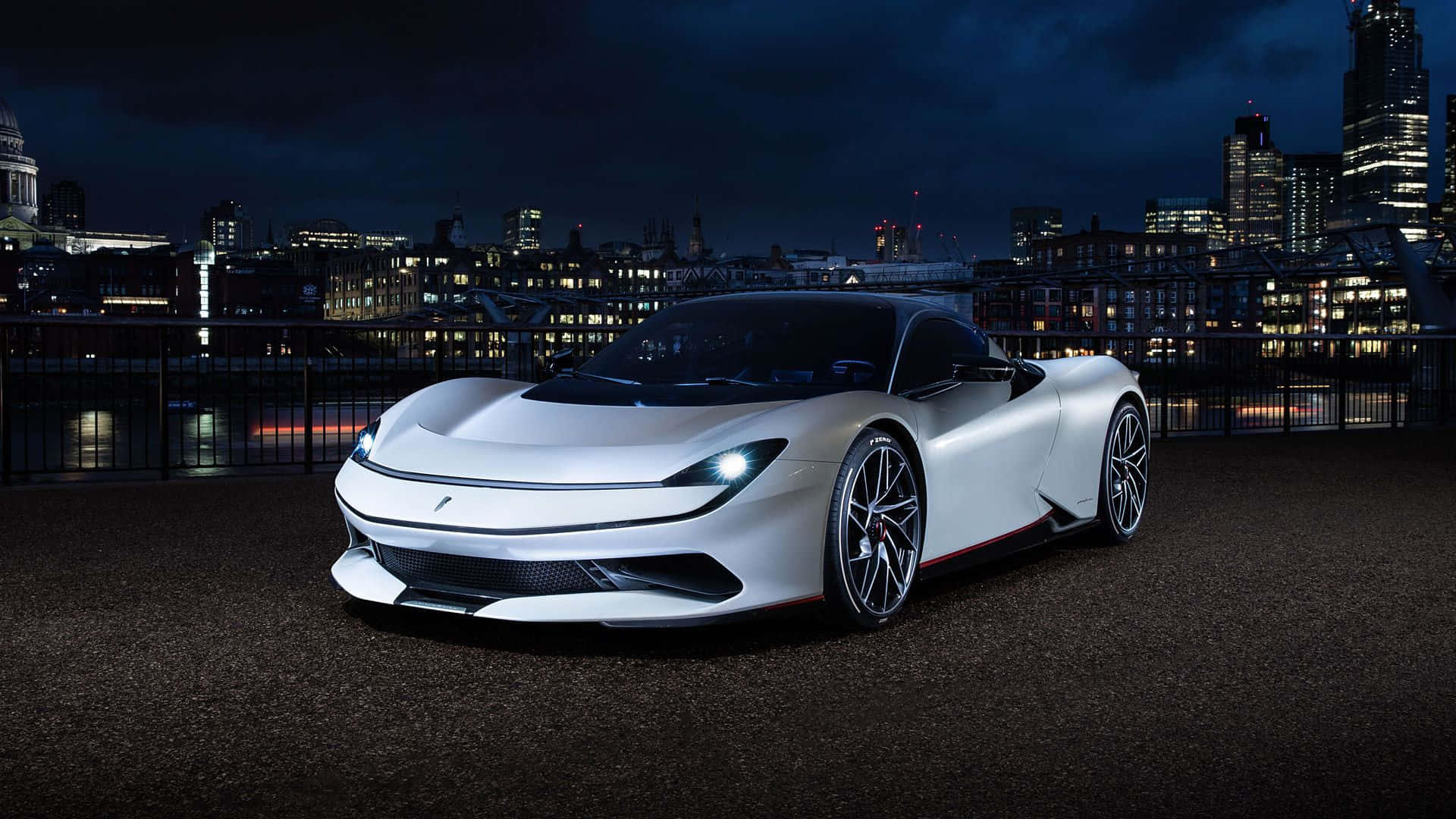 Pininfarina 桌布 壁紙 — 一輛時尚的白色跑車在夜燈下閃耀，背景是充滿活力的城市天際線和燈火通明的摩天大樓。