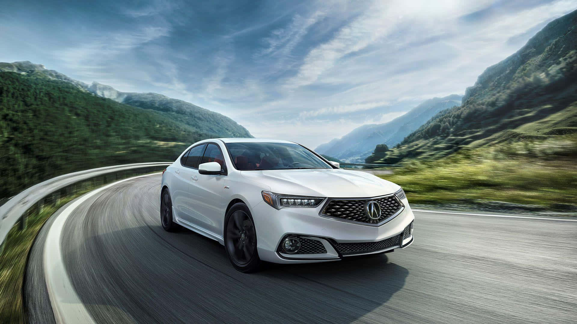 Acura Tlx 桌布 壁紙 — 一輛時尚的白色轎車沿著蜿蜒的山路疾馳，背景是鬱鬱蔥蔥的綠色山丘和動態的天空。