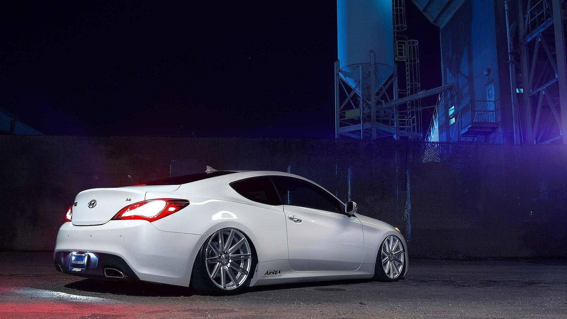 Hyundai 桌布 壁紙 — 一輛時尚的白色運動型轎跑車在工業區夜晚的霓虹燈下閃耀。