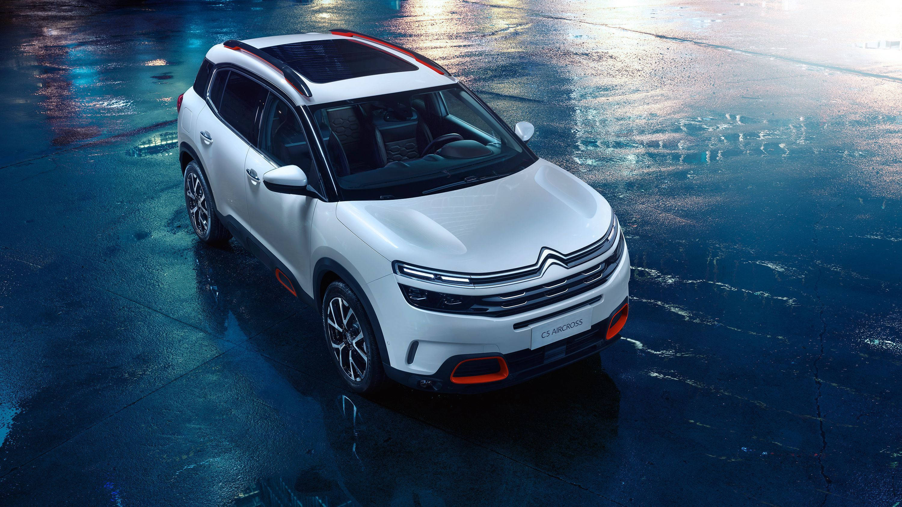 Citroen 桌布 壁紙 — 一輛時尚的白色雪鐵龍SUV在潮濕的城市街道上閃耀著霓虹燈光，反射出鮮豔的藍色和橙色色調。