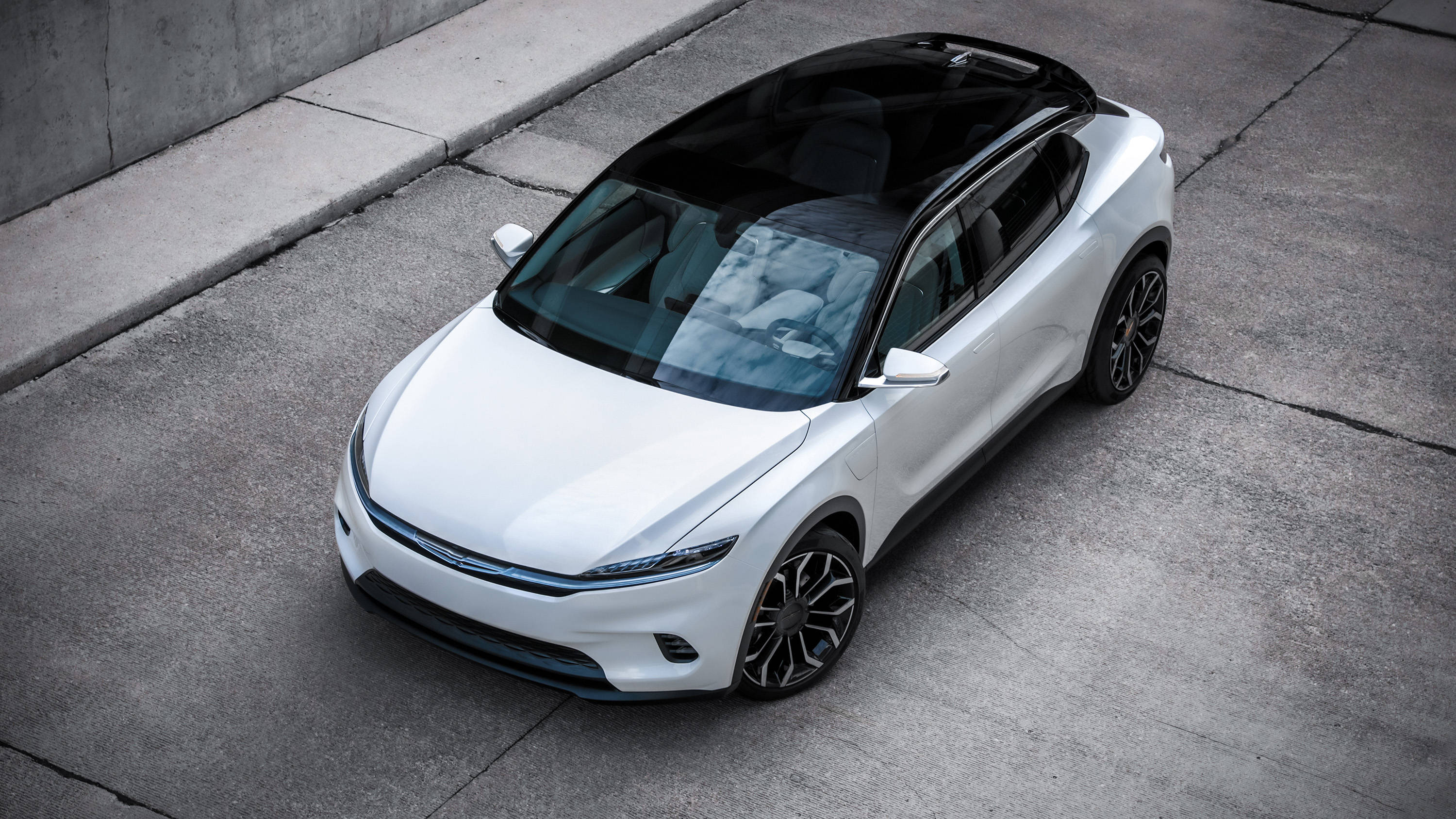 Chrysler 桌布 壁紙 — 一輛時尚的白色電動SUV，黑色車頂和車輪，停在灰色混凝土上。