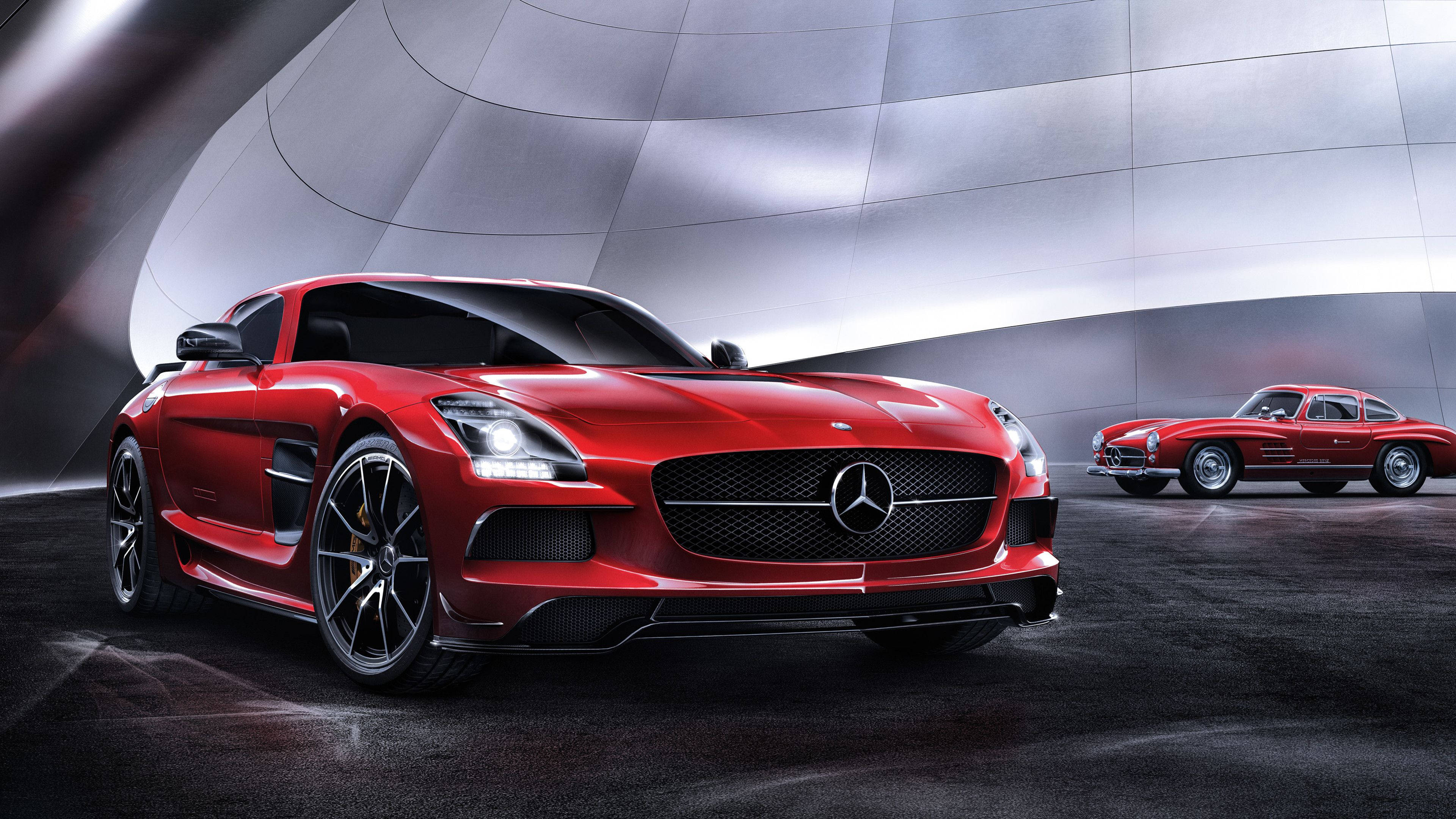 4K 奔馳壁紙 桌布 壁紙 — 一輛時尚的紅色 Mercedes SLS AMG 跑車在未來感金屬隧道中，於攝影棚燈光下閃耀，旁邊是一輛經典的紅色 Mercedes 300 SL Gullwing。